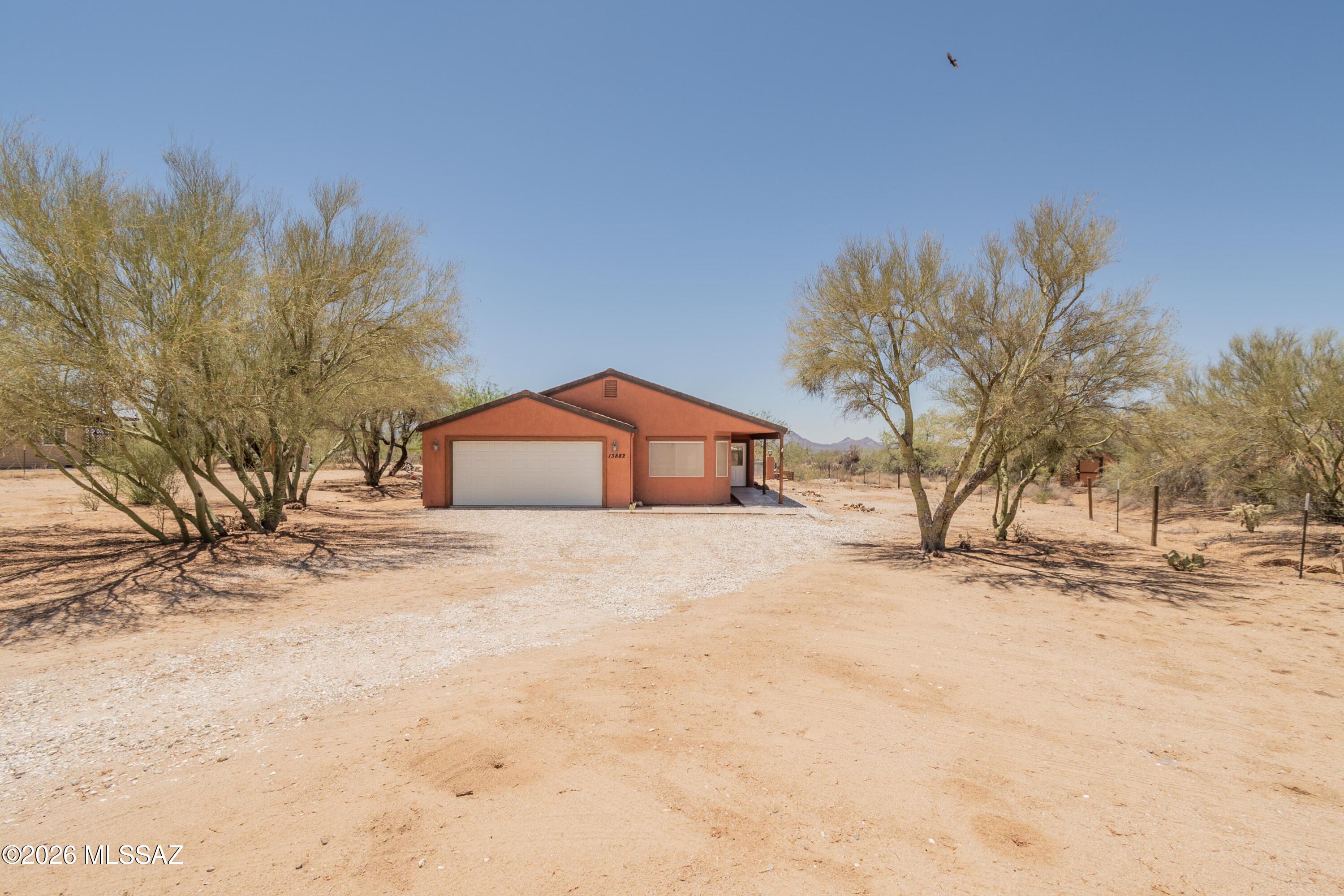 Escape to peaceful country living in Diamond Bell Ranch! Located 40 minutes west of Tucson, this move-in-ready 3-bedroom, 2-bath home offers 1,488 sq. ft. of living space on a private 1.5-acre cul-de-sac lot with breathtaking mountain views and stunning Arizona sunsets. The open-concept floor plan features a spacious great room and an eat-in kitchen with stainless steel appliances, two pantries, and pull-out shelves. Enjoy outdoor living on the expansive covered patio with remote-controlled solar screens, providing the perfect place to barbecue, entertain guests, or simply relax and enjoy the peaceful surroundings. Nature lovers will appreciate the abundant wildlife and star-filled desert skies right from their backyard. Experience the beauty, privacy, and tranquility of Diamond Bell Ranch