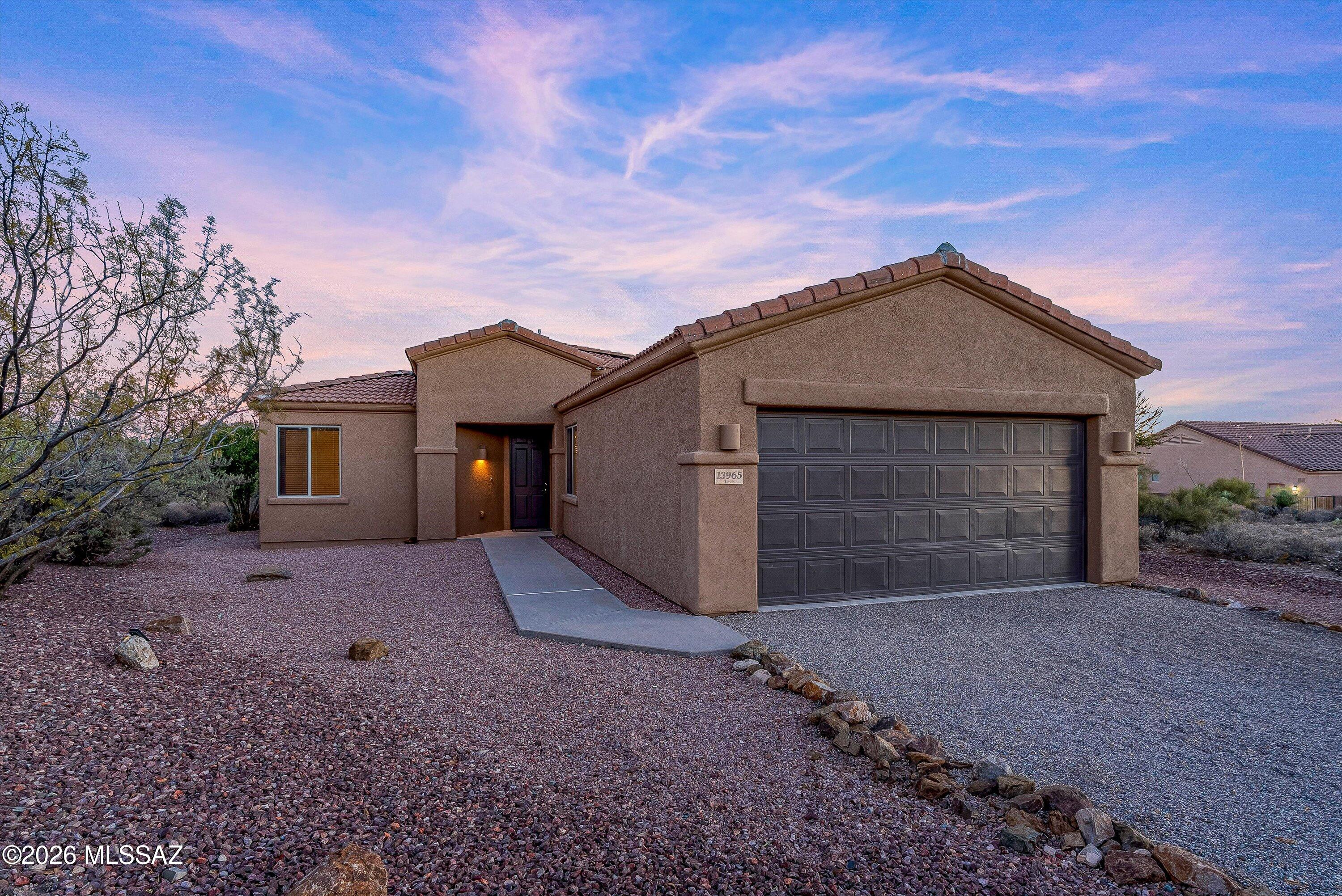 Step into this stunning residence built in 2006, offering an impressive 1,712 square feet of thoughtfully designed living space. This home boasts three well-appointed bedrooms and two full bathrooms, including a luxurious master suite that features dual sinks set in cultured granite, a spacious soaking tub, and a separate shower for ultimate relaxation. Nestled on a sprawling one-acre lot, the property is enclosed by a secure wall, providing both privacy and tranquility within the esteemed gated community of JD Ranch, all while being part of the award-winning Vail School District and conveniently located near I-10 for easy commuting. The kitchen is a chef's delight, showcasing elegant granite countertops paired with sleek black appliances, making it both functional and stylish. Throughout the home, you'll find durable ceramic tile flooring, complemented by fresh new carpeting in the bedrooms, and real wood blinds that add a touch of sophistication. The inviting living room features a cozy fireplace, perfect for gathering with loved ones. The master bedroom is a true retreat, complete with a walk-in closet and direct access to the expansive backyard, which is a blank canvas ready for the new owner's personal touch. Additional features include low-maintenance landscaping in both the front and back yards, breathtaking mountain views, ceiling fans in every room for added comfort, and a two-car attached garage with epoxy flooring that enhances durability and style.