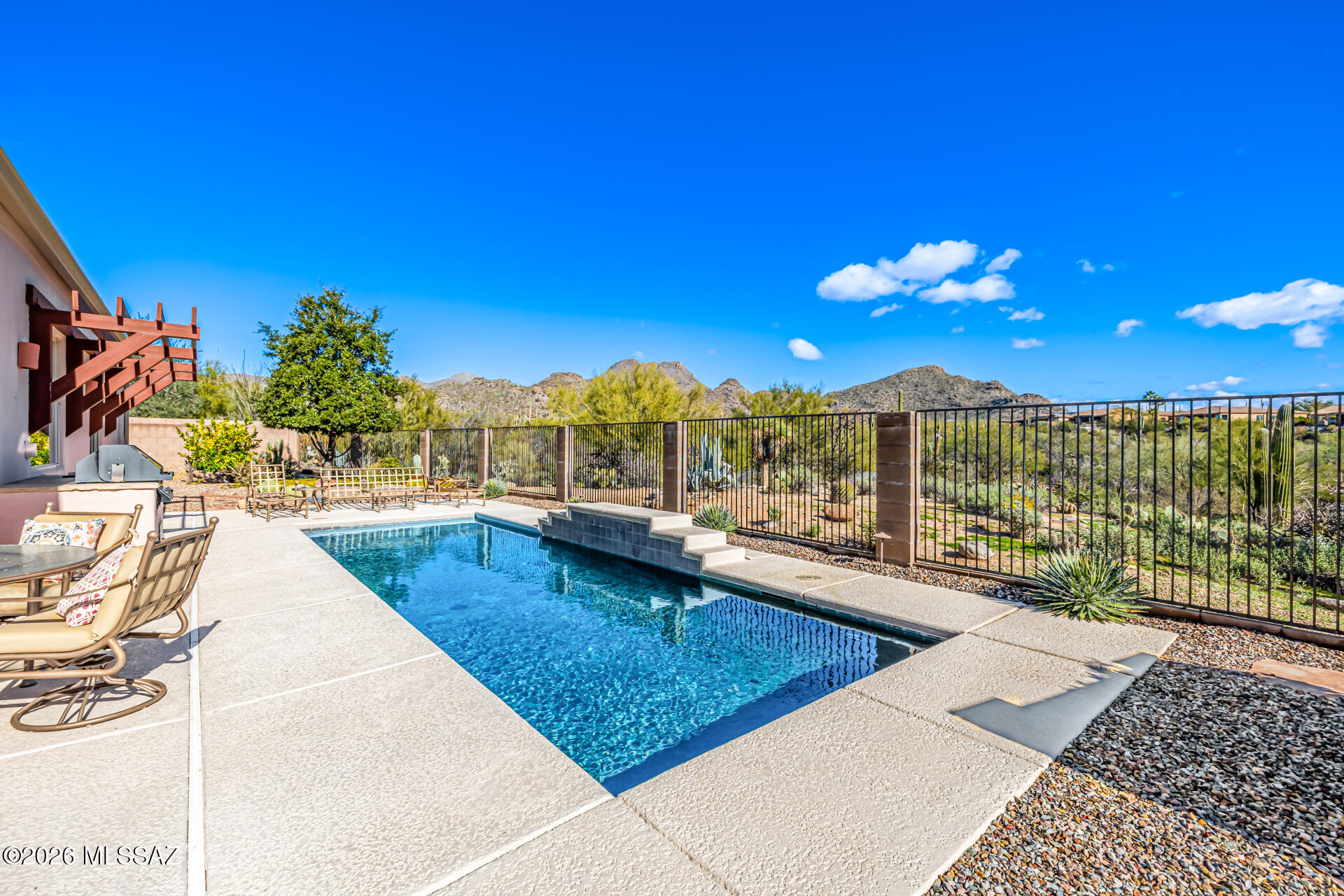 COME SEE THIS DOVE MOUNTAIN GEM! Offering beautiful mountain views in this gorgeous pool home! This home welcomes you with a vibrant landscape and a 3-car garage. Inside, you'll find warm and inviting living spaces featuring tile flooring, carpet in select areas, soaring ceilings that add an airy feel, contemporary lighting, a fireplace to ensure cozy winter evenings, and an earthy color palette throughout. The impeccable kitchen and dining area overlook the mountains, giving you a serene scenery while cooking your delicious dishes. The space is equipped with ample cabinetry, tile backsplash, granite countertops, and stainless steel essentials. Get a good night's rest in the main retreat, providing a private exit to the patio, a walk-in closet,  a full ensuite with double vanities. sinks and a separate shower & tub. The cozy den is perfect for a home office or a creative area. Out back, you'll have your oasis, complete with a covered patio where you can relax with your favorite drink, a built-in BBQ, a nice seating space, and a sparkling pool perfect for sunny days, as well as a view fence, so you can admire the magnificent scenery. This gem is truly a must-see!