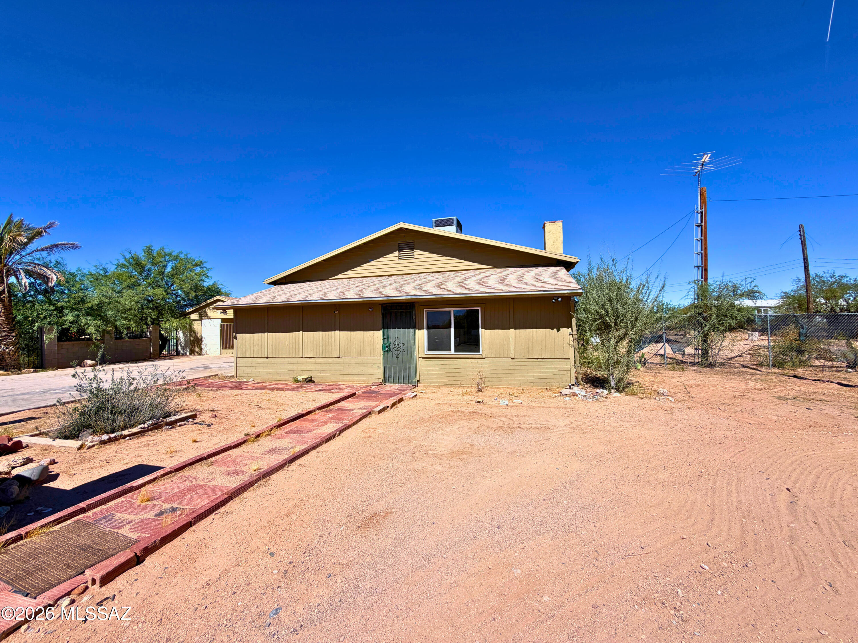 2.87 acres with frontage on Old Nogales Highway. Two lots with two tax parcels included in this sale. Room for all your toys, parking and animals.  Bring your horses and make this your own equestrian property. Front lot is 1.3 acres and has a detached carport with a shop and storage, and the Quonset hut on a cement pad gives you plenty of covered parking. The front of the property is fenced with a rolling security gate. The house features 2 bedrooms, 1 bathroom and 970 sq ft. The back 1.57 acre lot is native desert, build on it or use it for privacy. This lot is flat and has room for whatever you want: animals, dirt bikes, parking or storage. Rent the house and use the rest of the property for storage. Come make this house shine again and build this unique property into whatever you want!
