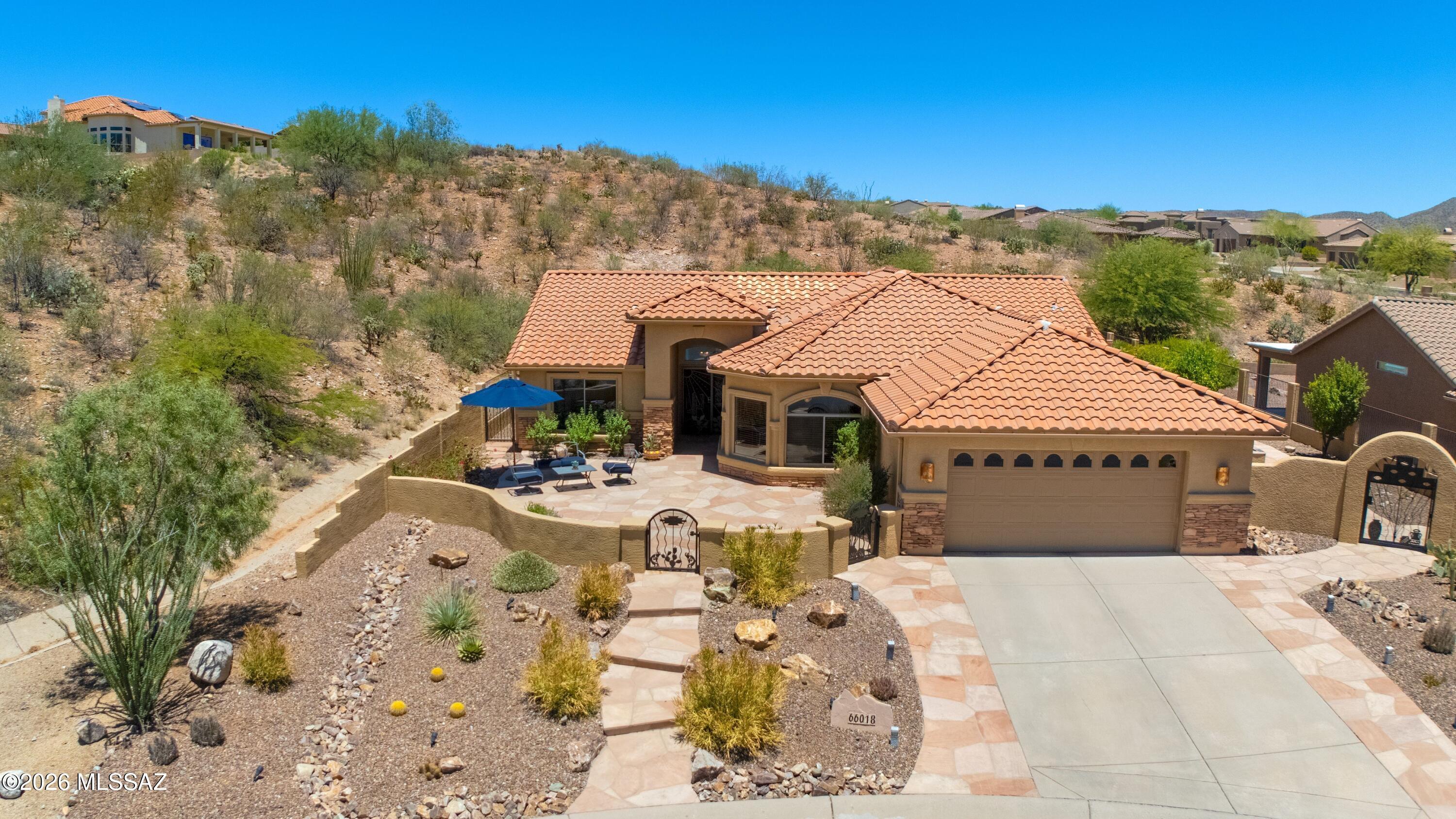 Updated Laredo with Pool, Spa, & Mountain Views! Great Curb Appeal! Custom gates open to front courtyard with mountain views. Great Room has patio slider for indoor/outdoor living. Kitchen offers granite counters, stainless appliances, gas range, soft-close cabinets with slide-out shelving & dining area. Owner's Suite has patio slider. En-suite bath with walk-in shower & closet. Den/Office. Guest Bedroom with closet & nearby Guest Bath. Laundry Room with W/D & cabinets. Tile floors throughout. Extended 2-car garage includes cabinets, side service door, & 2022 W/H. Private outdoor oasis with covered patio, extended pergolas, built-in BBQ station, firepit, raised flower beds with roses, sparkling pool, relaxing spa, gated yard, surrounded by nature & mountain views-perfect for entertaining!