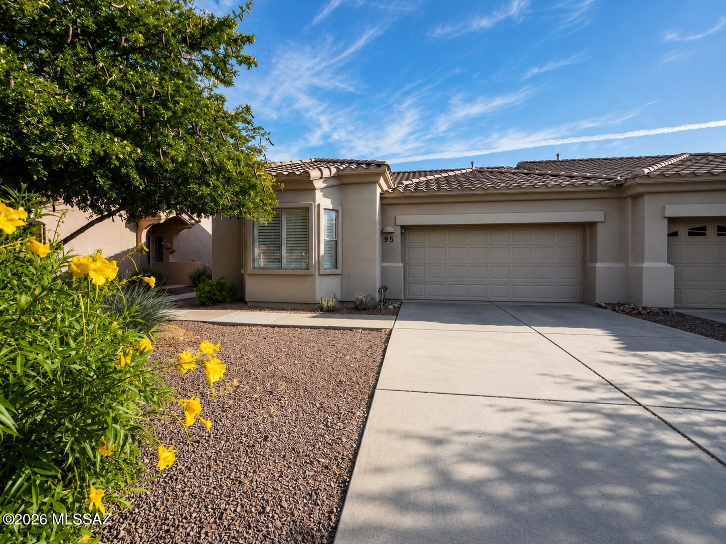 Discover a popular Chula Vista model situated on a private lot within the gated, age-restricted community of Vistoso Village. This light and bright home with an open floor plan features a 2-bedroom, 2-bathroom plus den, covering 1,593 square feet. With vaulted ceilings, window shutter throughout, tile flooring in all wet areas, and carpeting in the main living areas, this townhome is truly a must-see! The kitchen seamlessly connects to the great room and offers abundant cabinetry, oak cabinets, laminate countertops, a white appliance package, and a convenient bar area for seating. The generous primary suite boasts a dual vanity, a spacious walk-in shower, and a walk-in closet. The secondary suite provides plenty of room and privacy for your guests. The versatile flex room offers endless possibilities for use. This home also includes a 2-car garage with a storage cabinet and a fully enclosed backyard surrounded by lush foliage. There are countless features to appreciate in this well-maintained townhome! The HOA fee covers- water/sewer, trash/recycle pick-up, cable TV, in-home WiFi, front/backyard landscaping, exterior painting, monthly pest control to include termite, roof, structure insurance, gate for security, and clubhouse access, making more time for homeowners to enjoy everyday life!