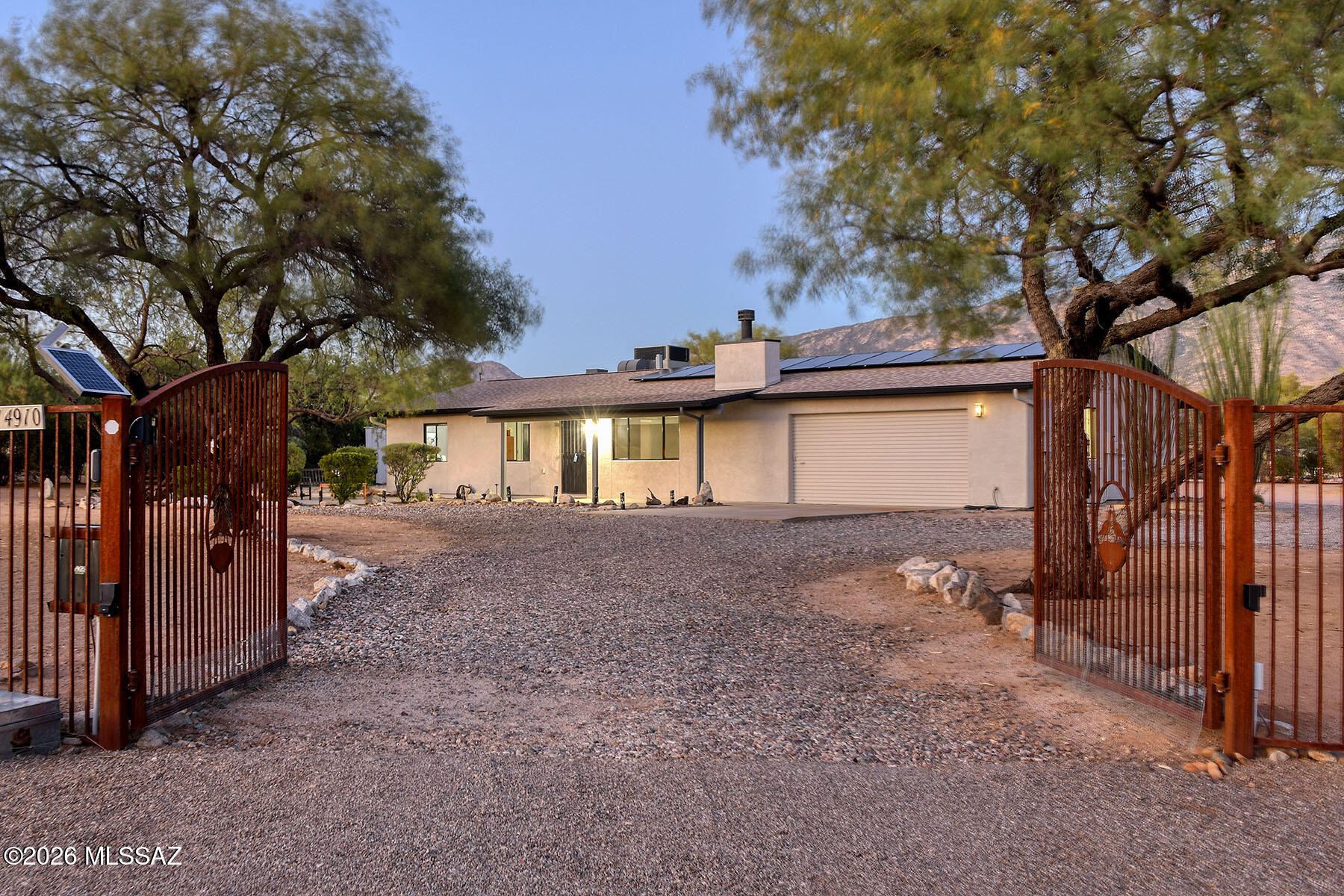 Picture PERFECT mini-ranch with a private motorized gate , fabulous mountain views & serene privacy. A light & open floor plan invites you into this exceptional home featuring a Great Room with fireplace, large picture window, lovely dining area, totally remodeled kitchen with new cabinets, quartz countertops, stainless steel appliances, pantry, 3 bedrooms & 2 baths including primary bedroom with walk- in closet & sliding doors to the rear patio, no carpet throughout,  laundry room with washer & dryer, & a 2 car garage with a large storage room. Enjoy the incredible backyard with covered patio, new hot tub plus covered RV carport with full hookup with water, 220/110 electric, plenty of open area for horses, solar lease agreement at $182 a month, continued...... continued.....  no HOA (could be a great part time VRBO), circular driveway with 2 motorized gates, dramatic views of Pusch Ridge, what more could you want?