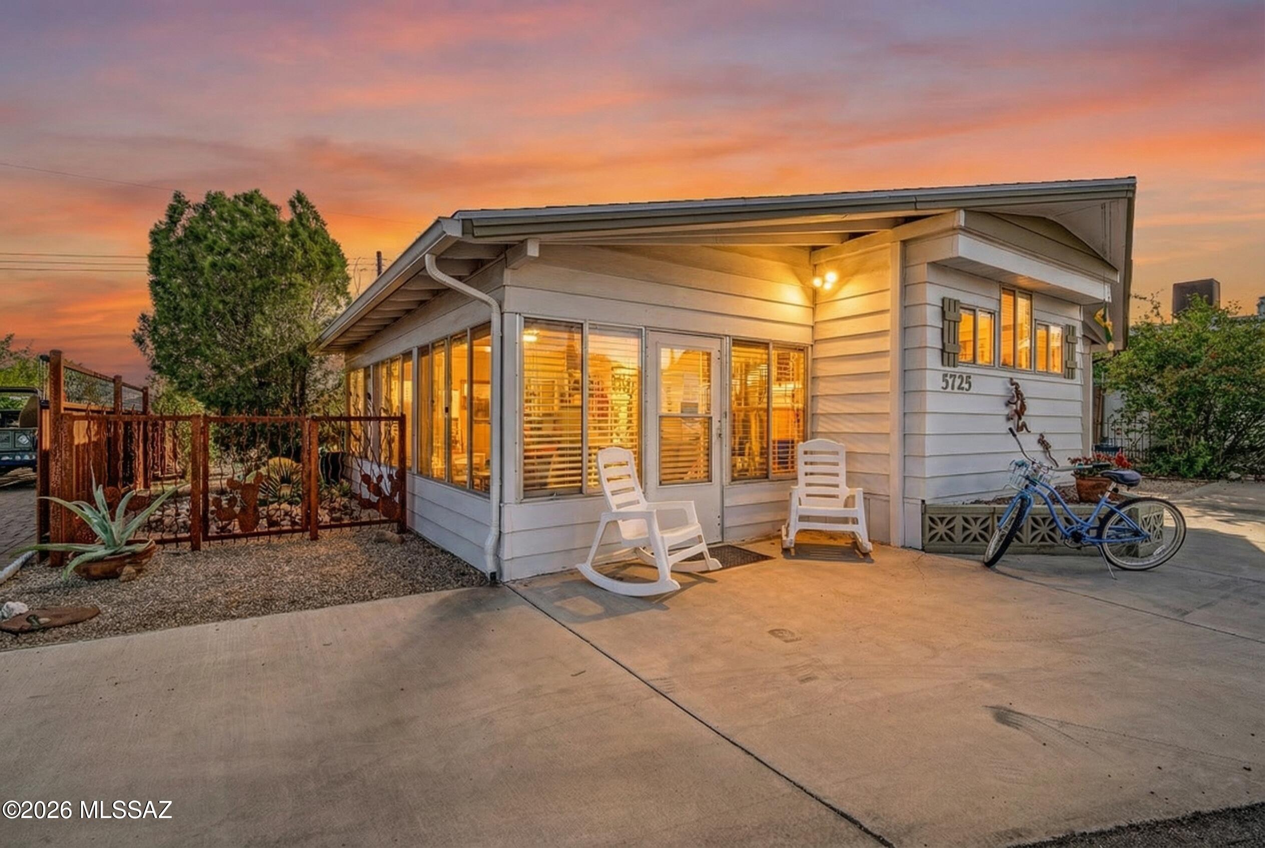 Discover irresistible midcentury charm in Tucson Estates! This 1,152 sq ft gem features a vaulted-ceiling Arizona room with breathtaking mountain views and warm, character-rich details throughout. Enjoy flexible comfort with central A/C & heat or energy-efficient zoned mini-splits. Thoughtful updates include a 2021 water heater, new bedroom mini-split, dual-pane windows in the primary bedroom, and a brand-new shingle roof with 5-year warranty. Outside, a rustic steel privacy fence offers rare seclusion & pet-friendly space, while an oversized carport sits beneath a stunning wood ramada roof covering the entire home. You own the land! Vibrant 55+ living with a low $208 HOA -18 hole golf, heated pool, lap pool, spa/sauna, pickleball, clubs, & more - perfect for snowbirds or Tucson newcomers! A desert landscaped backyard draws in hummingbirds, woodpeckers and other native bird species and butterflies. The mountain views both coming and going on Tumbling F never fail to impress, sunset is particularly gorgeous. Close to trails leading into Tucson Mountain Park and Saguaro National Monument, this desert community that's both Tucson adjacent yet firmly amongst the beauty of the Sonoran desert is the epitome of quaint AZ charm!