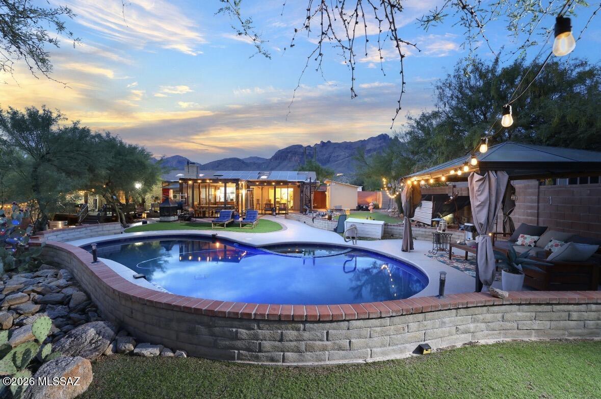 Welcome home! Ideally located just minutes from Tucson's premier amenities, including La Encantada, Fleming's, La Paloma, top-rated schools, and some of the area's best hiking trails.
This inviting home features a welcoming floor plan with a front living room highlighted by a large picture window that showcases the beautiful mountain views. Recent updates include fresh interior paint, stunning new tile flooring, upgraded LED lighting, an updated kitchen with gorgeous granite countertops, matching granite in the bathrooms, a new tankless water heater, and much more.
Currently configured as a three-bedroom home, there is also a spacious bonus room that could easily serve as a fourth bedroom, home office, or private study. Please see additional comments Once you've fallen in love with the interior, the outdoor living spaces are sure to impress. Step through the enclosed Arizona room, located just off the oversized private laundry room, and into your fully covered, screened-in patio, which is fully permitted and perfect for outdoor projects, family dinners, or arts and crafts while being protected from the desert wildlife.
The resort-style backyard is an entertainer's dream, featuring a freshly re-pebbled pool and spa with a newly painted pool deck. A covered ramada provides the perfect setting for barbecues, gatherings with family and friends, or simply relaxing and escaping the summer heat.
The primary suite offers its own private deck, where you can step outside each morning or evening to enjoy beautiful city views. A steel staircase leads to an incredible rooftop deck with panoramic mountain and city views, creating a one-of-a-kind space to watch Arizona's spectacular sunsets.
This home has been lovingly cared for and offers numerous additional upgrades, including a well-maintained roof, paid-off solar for significant energy savings, a recently replaced insulated garage door, an upgraded water softener, and a central vacuum system throughout.
Come experience this exceptional home for yourself, schedule your private showing today