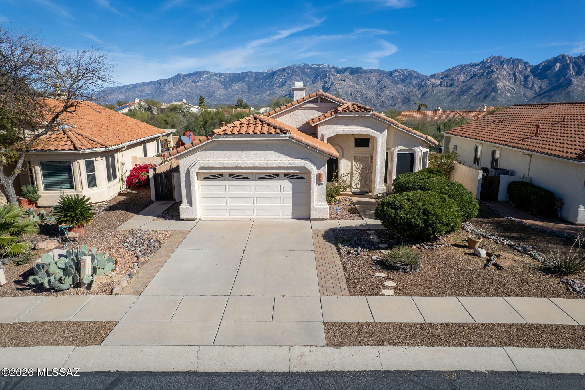 Rare opportunity to take in a one of a kind mountain view from your own backyard! Upgraded with new paint & carpet, this home is move in ready - waiting for you. Offering over 1,800 sq ft, enter into a large living/formal dining space w/ tile, ushering into den + gourmet kitchen. A true center for serving and entertaining, kitchen is equipped w/ upgraded counters & island, w/ breakfast bar & eat in nook accompanied by views of Pusch Ridge & gas fireplace. Head out to your covered back patio and take advantage of the built in BBQ and citrus trees - all backing up natural green space. Complete w/ 4 bedrooms, 2 baths, 2 car garage & built in storage and more! Don't miss out!