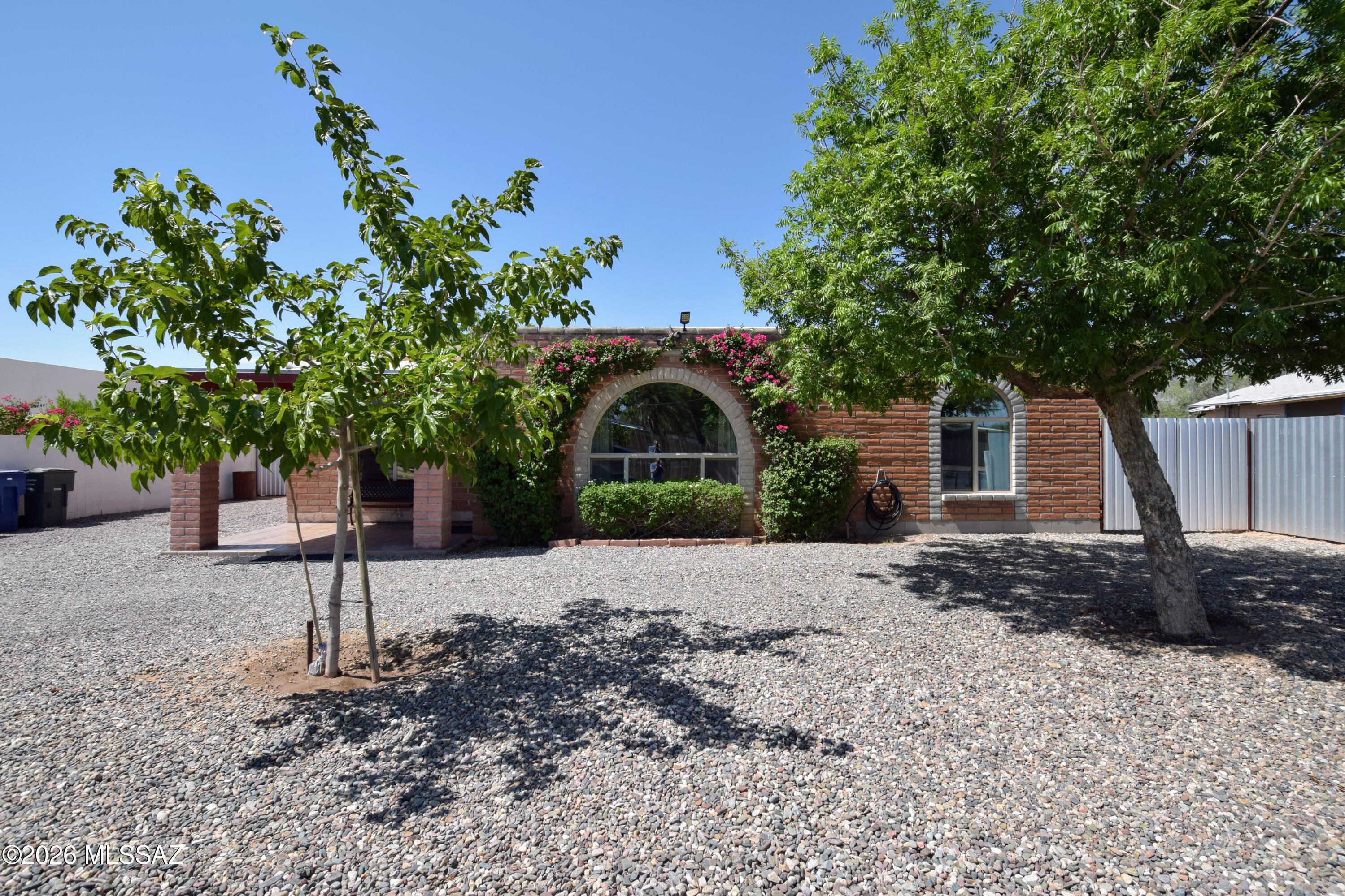 Located in the convenient Limberlost neighborhood of North-Central Tucson, this beautifully updated 1,598-square-foot single-family home seamlessly combines modern amenities with classic Southwestern charm. The inviting interior features durable wood or tile flooring and ceiling fans, keeping the entire space cool alongside the efficient central air conditioning and central heating systems. The main living area serves as a striking centerpiece, boasting recessed lighting, a stunning double pane arched picture window that floods the room with natural light, and a burnt adobe fireplace. Flowing effortlessly past the formal dining area, the fully remodeled modern kitchen comes equipped with granite countertops, crisp gray cabinetry, stainless steel appliances, and a matching hood fan. The home offers three bedrooms and two bathrooms, highlighted by a guest bath with granite counters, a large medicine cabinet, and custom tile surround. The expansive primary suite features his-and-her closets alongside an attached primary bathroom updated with a modern vanity and an ADA accessible roll-in shower. For ultimate daily convenience, full-size laundry units are included inside the property, and hassle-free off-street parking is located right out front. Step into the expansive backyard to find a secure space enclosed by metal fencing, featuring a large red brick covered patio perfect for outdoor relaxation or entertainment, along with a dedicated storage shed for extra gear. Negotiable pet policy, allowing dogs to be considered on a case-by-case basis. This home places residents minutes away from local shopping, dining, parks, and major Tucson thoroughfares.