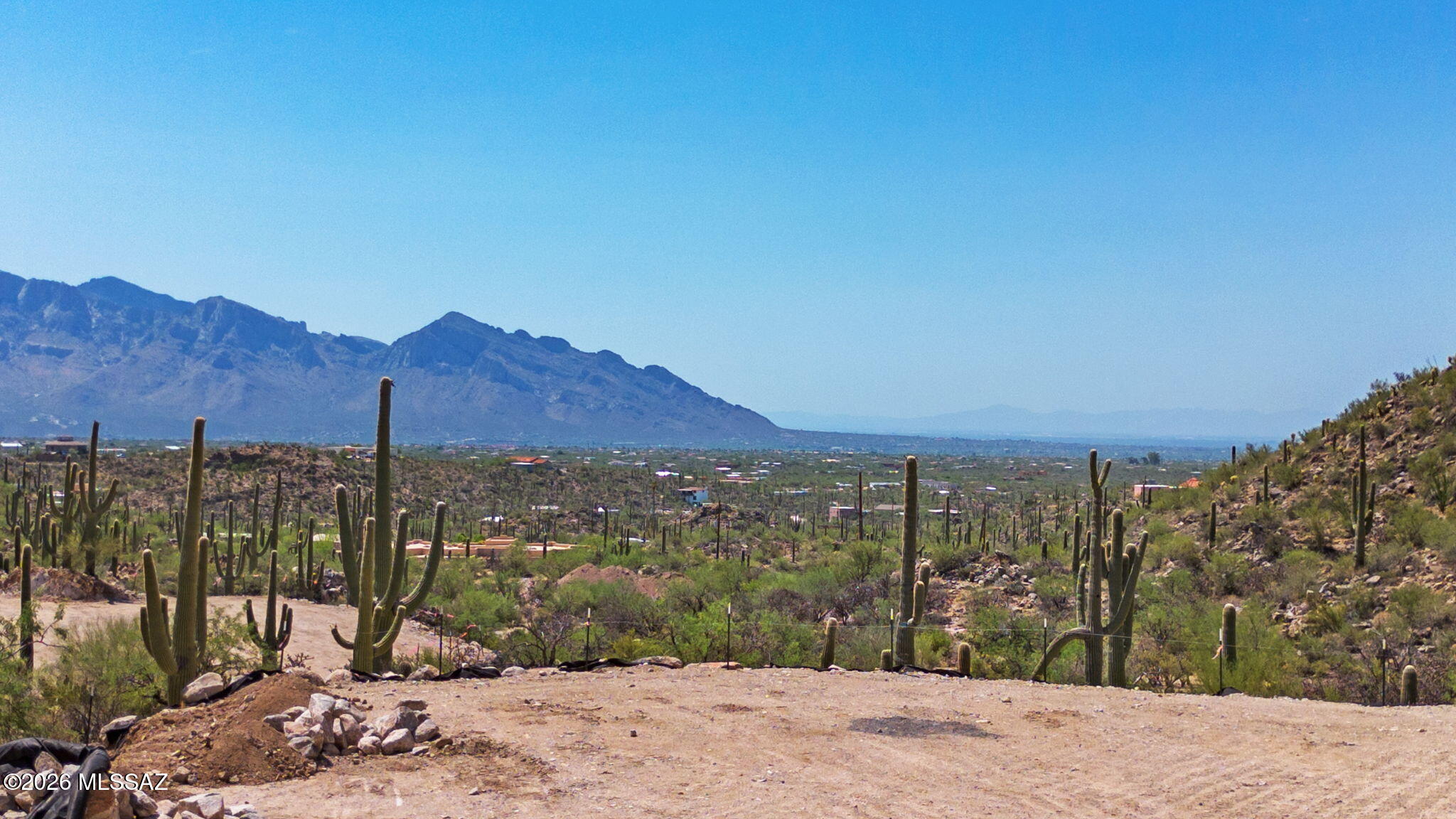 Breathtaking 4.41-Acre Homesite with Immense Views, County-Approved Plans, Shared Well Site & No HOA! Seller is a local builder who offers the opportunity to build the home depicted in the conceptual plans through a separate construction contract. Listing price is for the vacant land only. Discover a perfect blend of serenity, scenery & convenience with this rare parcel offering sweeping panoramic views of the mountains and desert landscape. Nestled just outside prestigious Saguaro Ranch-without the restrictions of an HOA- this open, build-ready lot provides the ideal setting for your dream home. The county-approved builder plans take into account the property's location within the beautiful Tortolita Mountain Buffer Zone, streamlining the building process. Buyers can personalize the design & finishes to match their vision while enjoying the convenience of a fast-tracked, modern build.