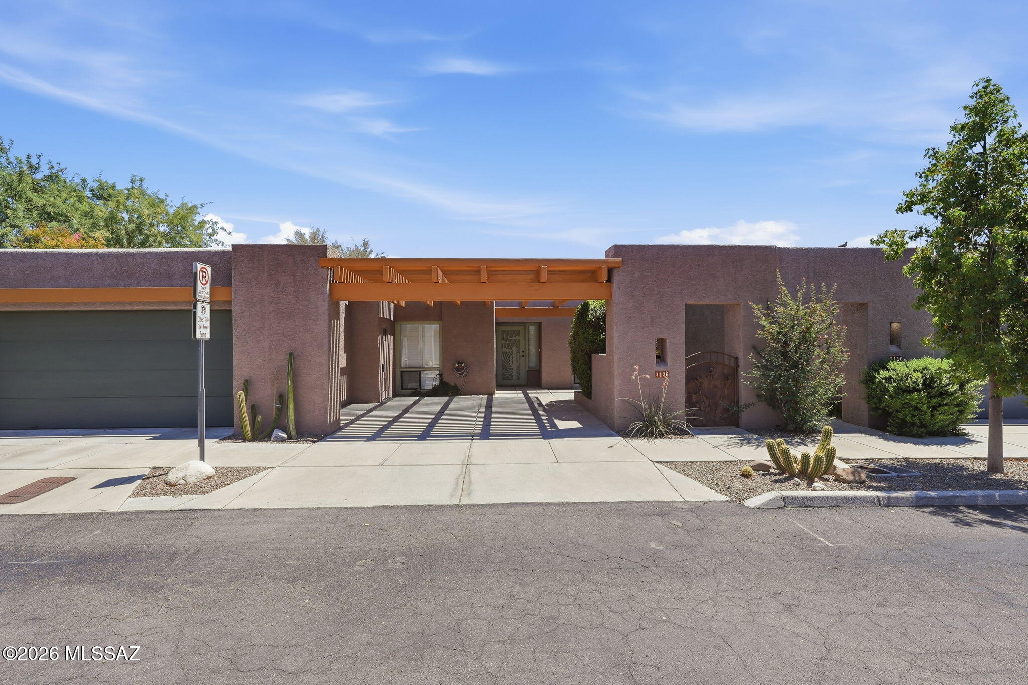 Ideally located in the heart of Tucson with quick access to The Loop, this charming townhome offers comfortable living, thoughtful updates, and low-maintenance convenience. Recent improvements include a brand-new roof (2026), refreshed interior and exterior paint, updated fixtures, a new refrigerator, and a beautifully remodeled primary bath featuring a new tub/shower with custom surround.  The spacious living room feels open and inviting with vaulted ceilings, a fireplace, media wall, stained concrete flooring, plantation shutters, and French door leading to the private patio. The kitchen features a breakfast nook, pantry area, and newer white appliances, while the flexible living and dining space accommodates a variety of lifestyles. The primary suite includes a walk-in closet plus an additional closet, dual vanities, linen storage, and a sliding door to the backyard. A laundry closet with newer washer and dryer, north-facing guest bedroom, and convenient storage room off the courtyard/carport add to the home's functionality.  Enjoy outdoor living on the private patio complete with a fireplace, banco seating, and a lemon tree. Backing to a common area between streets, the setting offers added privacy within this charming boutique community.