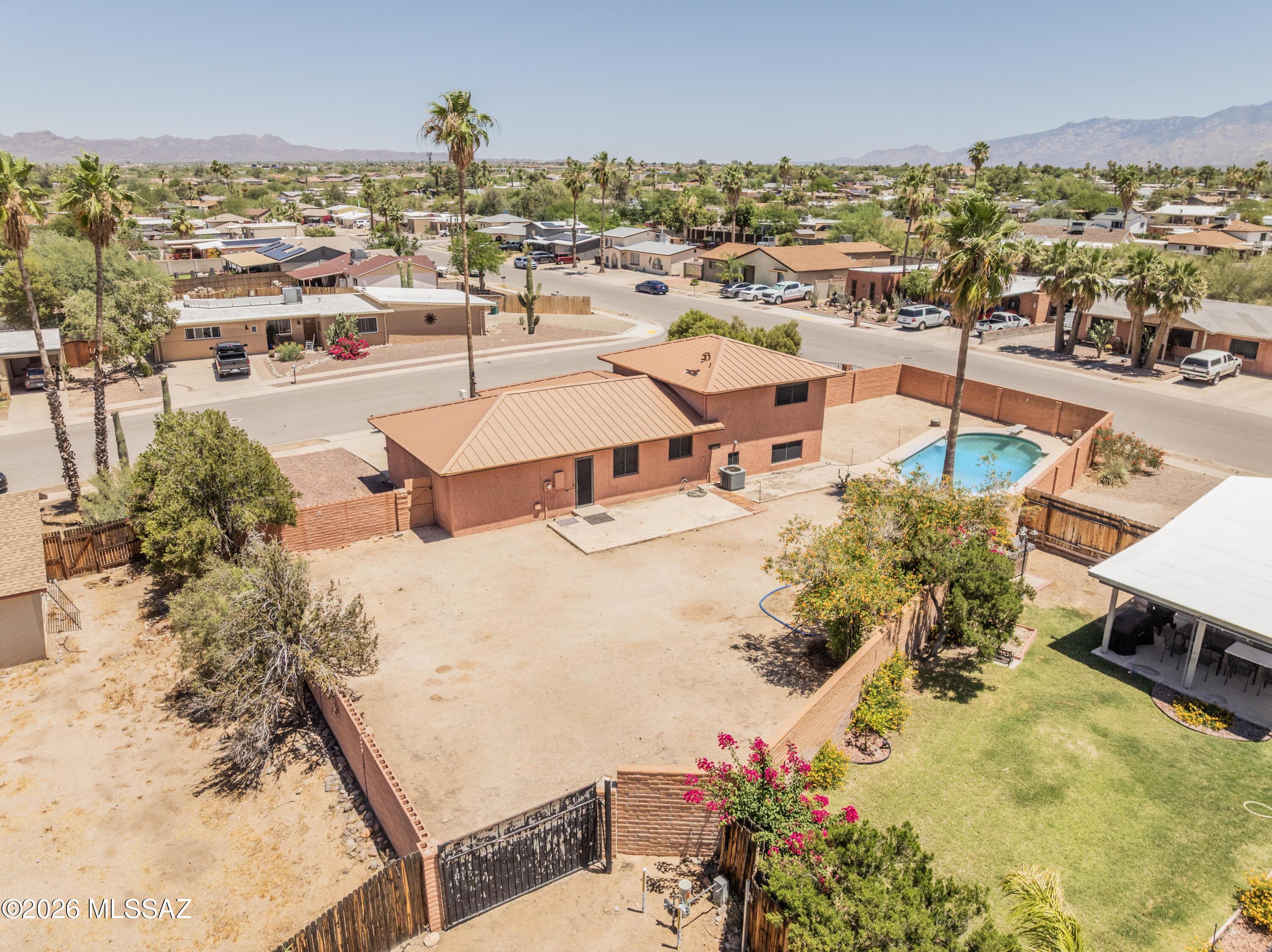 RANGE  PRICED $349,900-$369,900. Charming corner lot, multi level home with flexible space! 3 bedroom, 2 bath, with primary downstairs. 2 bedrooms and full bath on upper level. Saltillo tile floors throughout main living areas adds warmth and that hacienda feel. Metal roof, triple pane windows and security screens help with energy efficiency and comfort. Enclosed garage space has endless use! Or convert back to park your vehicles inside. Backyard has double gates to bring in all of your toys. Pool is ready for the hot summer days that are here. Bring the family and come take a look!
