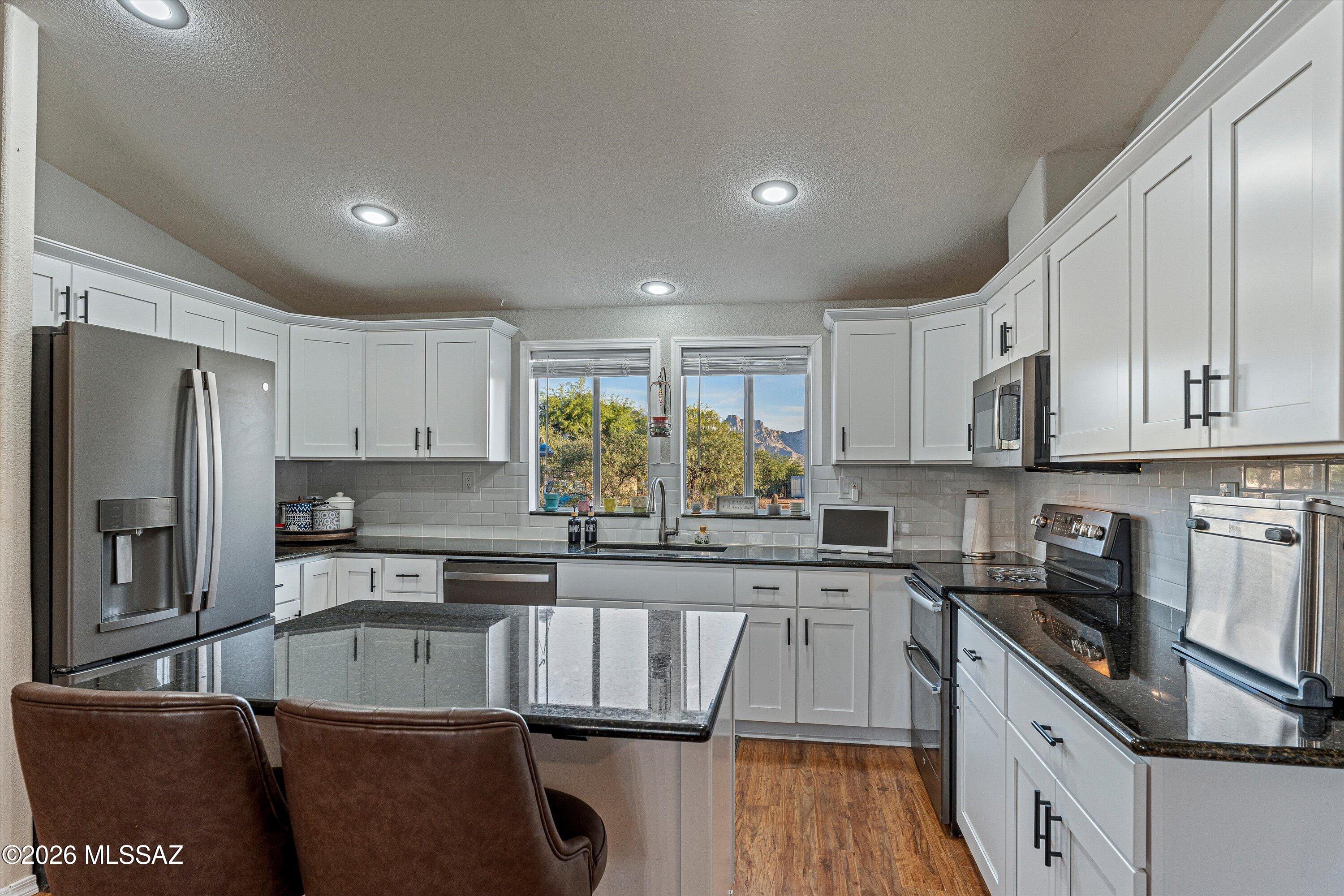 Enjoy stunning mountain views from this updated 4-bedroom, 2-bath home on a spacious 1-acre lot with mature trees and natural vegetation. The open floor plan offers comfortable living, while the updated kitchen features granite countertops, island, and newer appliances. Stylish wood-laminate flooring runs throughout. Split bedroom floor plan offers added privacy. Large walk-in pantry/mudroom just off the kitchen with private backyard access. Separate laundry room with its own exterior access adds convenience. Outside, you'll find a storage shed, RV parking, and room for additional vehicles or hobbies, plus an extra-large 2-car garage. Relax on the extended front covered patio. Move-in ready with room to live, work, and enjoy the Arizona life!