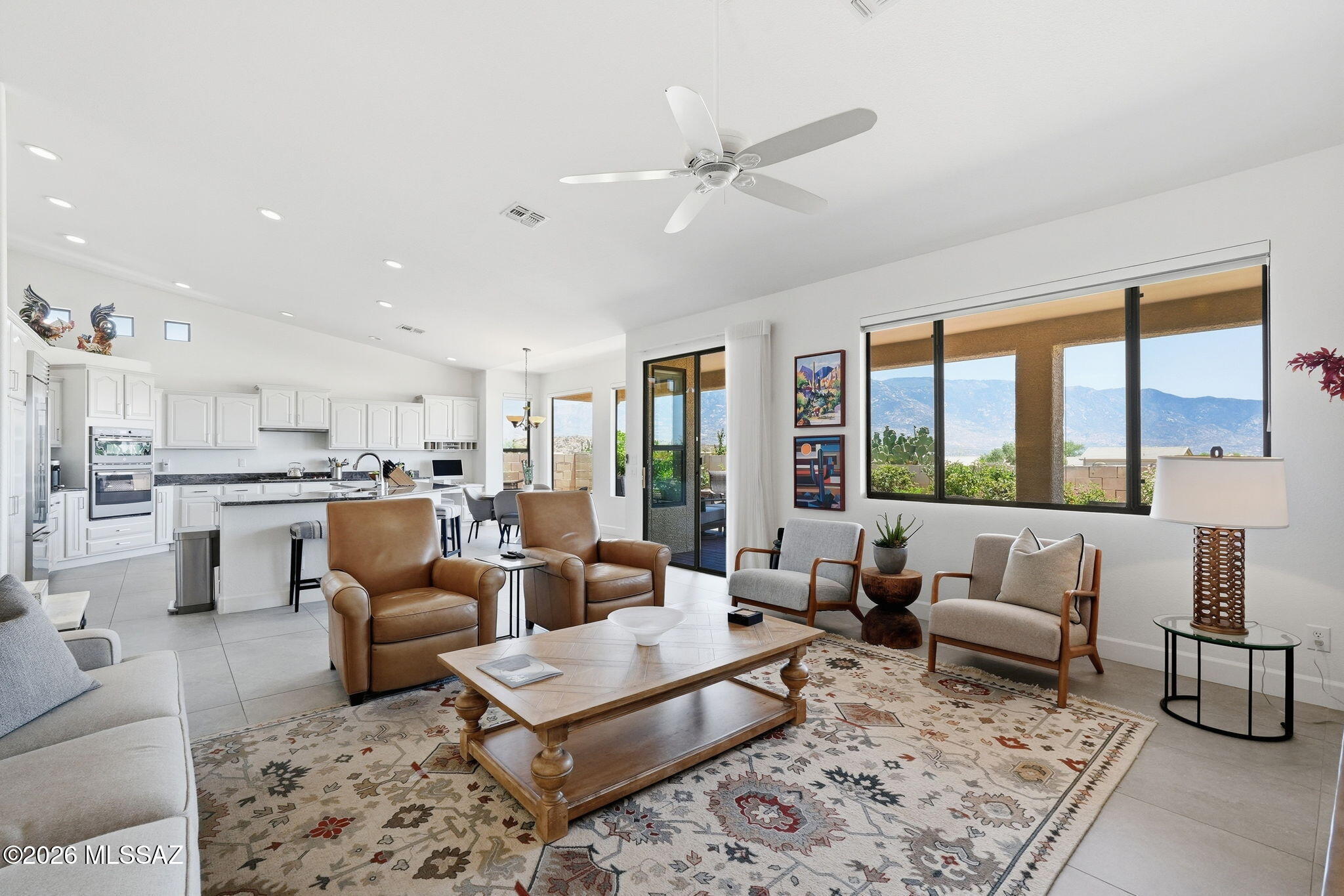 Perched on an elevated lot with breathtaking 180-degree mountain views, this beautifully renovated Durango model blends modern style with exceptional comfort. Double iron doors welcome you from the front paver patio into a light-filled interior featuring oversized 2' x 4' tile throughout the main level. The entertainer's kitchen showcases Sub-Zero refrigeration, convection/MW ovens, granite countertops, gas cooktop, cabinet pull-outs, a large island, and built-in desk area. Enjoy flexible living spaces including a family room with endless views, a living room with gas fireplace, and a custom office/bar. The luxurious primary suite offers stunning vistas, a spa-inspired bath, and customized closet. Upstairs, a private casita includes two bedrooms and bath. Additional highlights include ... remodeled guest and powder baths, a well-appointed laundry room, three-car garage, and expansive paver patio with multiple seating areas, stone planters, and sun screens for year-round outdoor enjoyment.