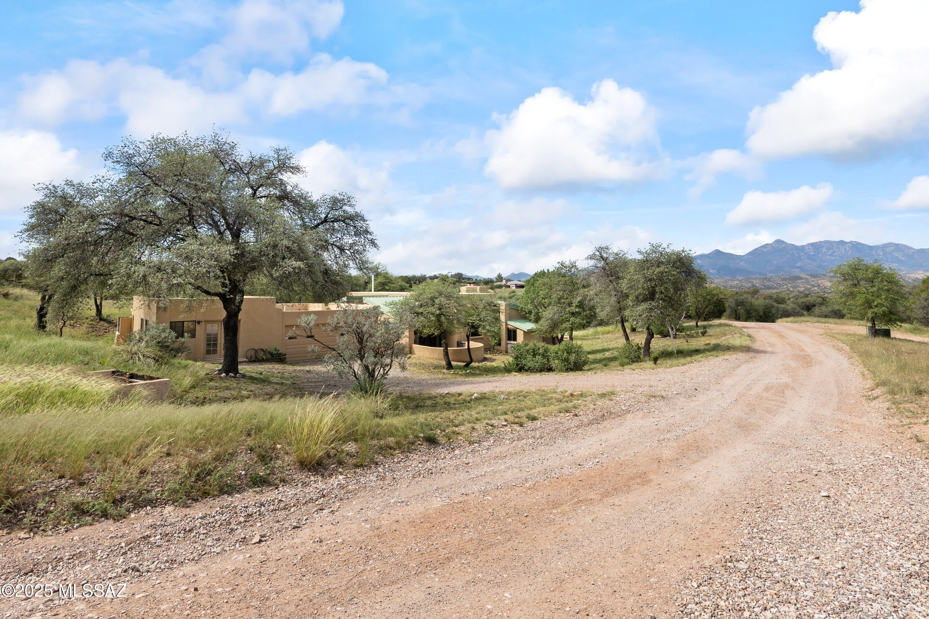 Welcome home to 50 Casas Arroyo, a tranquil retreat nestled in a quiet, private neighborhood in the heart of Sonoita, Arizona. This is more than just a house; it's a sanctuary where you can unwind and savor breathtaking mountain views from each of the four covered patios.

Crafted with exceptional skill, the home's interior and exterior walls are built from fired adobe block, with a classic stucco finish on the exterior, ensuring both beauty and durability. Step inside and be greeted by the warmth of a vaulted ceiling with tongue and groove planking, creating an open and airy ambiance. The heart of this home has been thoughtfully updated, with a substantial remodel completed just a few years ago. The modern kitchen is a chef's delight, featuring a tasteful blend of Majorca and subway tiles, polished concrete floors, and ample space for culinary creativity. The charm continues into the bathrooms, which also showcase beautiful tilework. You'll find elegant Saltillo tile flooring throughout the main living areas, while the bedrooms offer the plush comfort of new carpeting.

Comfort is paramount in this home, which offers a variety of heating and cooling options to suit any preference. A quiet and efficient dual-zone mini-split system with two indoor units provides targeted comfort, supplemented by a separate central ducted air conditioning system and ceiling fans throughout. For cozy evenings, gather around the pellet stove in the living room, or retreat to the master bedroom and enjoy the romantic glow of the kiva fireplace.

This home is not only beautiful but also practical. The recent remodel included a new metal roof, energy-efficient Anderson windows and sliding glass doors, and a tankless water heater for endless hot water. The water supply is from a regularly tested community well, providing peace of mind.

Storage will never be an issue, with an abundance of closets and storage space throughout the home, all illuminated by modern LED lighting. For your vehicles and hobbies, a detached two-car garage includes two large storage closets. Additionally, a separate studio building, complete with numerous outlets, electric heating, and ceiling fans, offers the perfect space for an art studio, workshop, or home office.

The property is a nature lover's paradise, with mature oaks, juniper, mesquite, and alligator spruce trees creating a low-maintenance, picturesque landscape. A dog door provides easy access to a fenced yard with a gate, giving your furry friends a safe place to roam. As part of this exclusive community, you'll enjoy access to a private pool and scenic hiking trails, all secured behind an entry access gate for your peace of mind and privacy.

To make your move even easier, the home conveys with black-out curtains, a refrigerator, and laundry appliances.

Don't miss this rare opportunity to own a piece of Sonoran paradise, where quality craftsmanship and modern amenities meet serene natural beauty. Your dream home at 50 Casas Arroyo awaits.