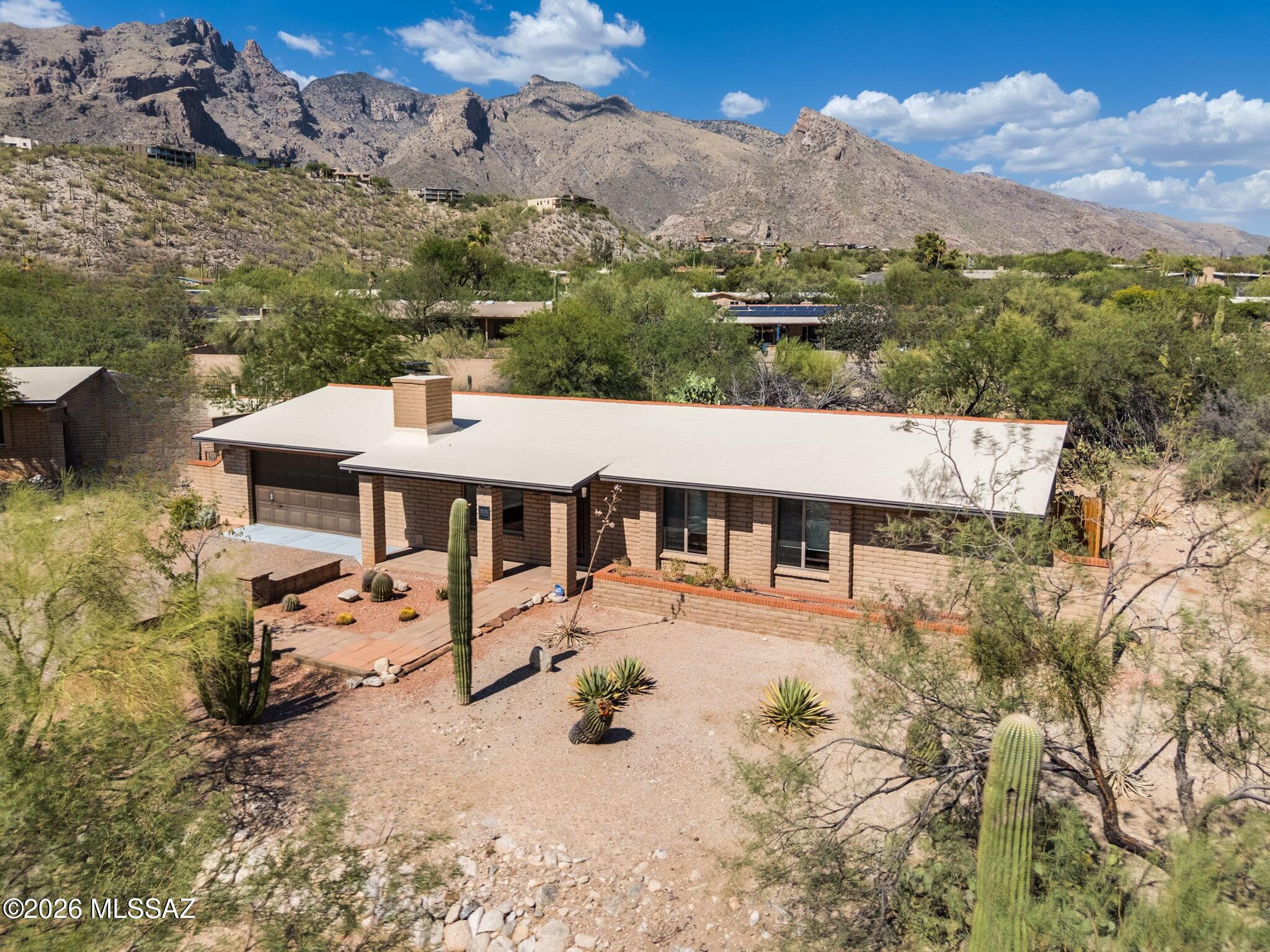 Enjoy breathtaking Finger Rock and Catalina Foothills views from this private 3-bedroom + office, 2-bath home nestled among the natural beauty of the Catalina Foothills. The spacious great room floor plan is designed for effortless living and entertaining. Fresh interior paint and stained concrete flooring throughout mean there's no carpet to maintain. Step outside to your private desert oasis featuring a sparkling Pebble Tec pool, relaxing spa, removable pool safety fence, and a brand-new Trex deck perfectly positioned to capture Arizona's unforgettable mountain vistas. The attached 2-car garage offers ample storage, while the desirable location places you just minutes from La Encantada, world-class hiking, and top-rated District 16 schools.