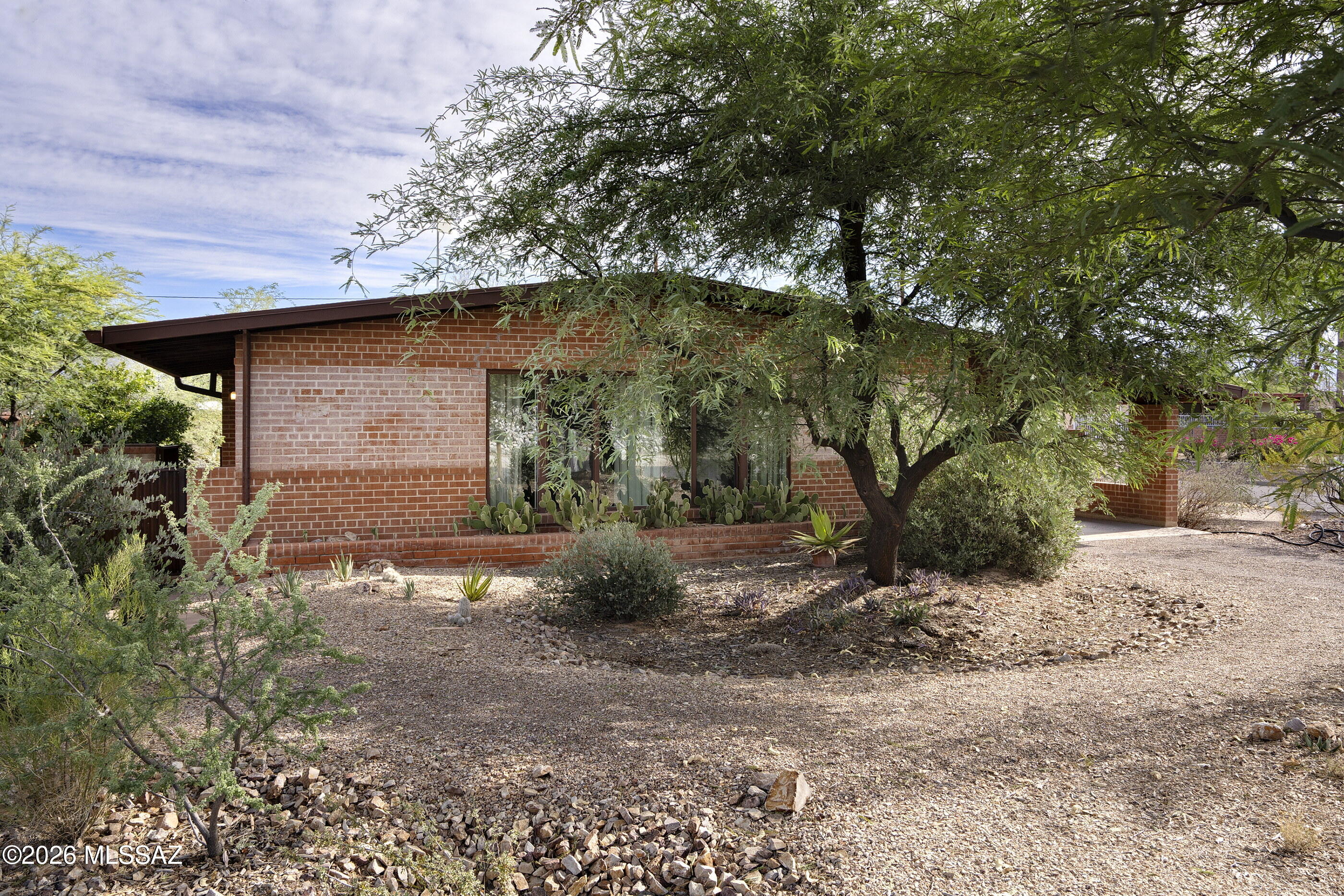 Thoughtfully updated 3 Bedroom, 2 Bath red brick bungalow in a desirable central neighborhood. The interior features a timeless custom kitchen with rich alder cabinetry, granite countertops, breakfast bar, stylish backsplash, and a large pantry. Improvements include newer appliances, recently installed heat pump, and owned solar. Gray concrete floors throughout. Front and back yards landscaped to sustain drought-tolerant plants, including shade trees, with greywater and rain tank systems installed. This home is situated on a generously-sized lot, and the expansive yard, which is enclosed by distinctive corrugated metal fencing, offers endless possibilities. Meticulously maintained and move-in ready.