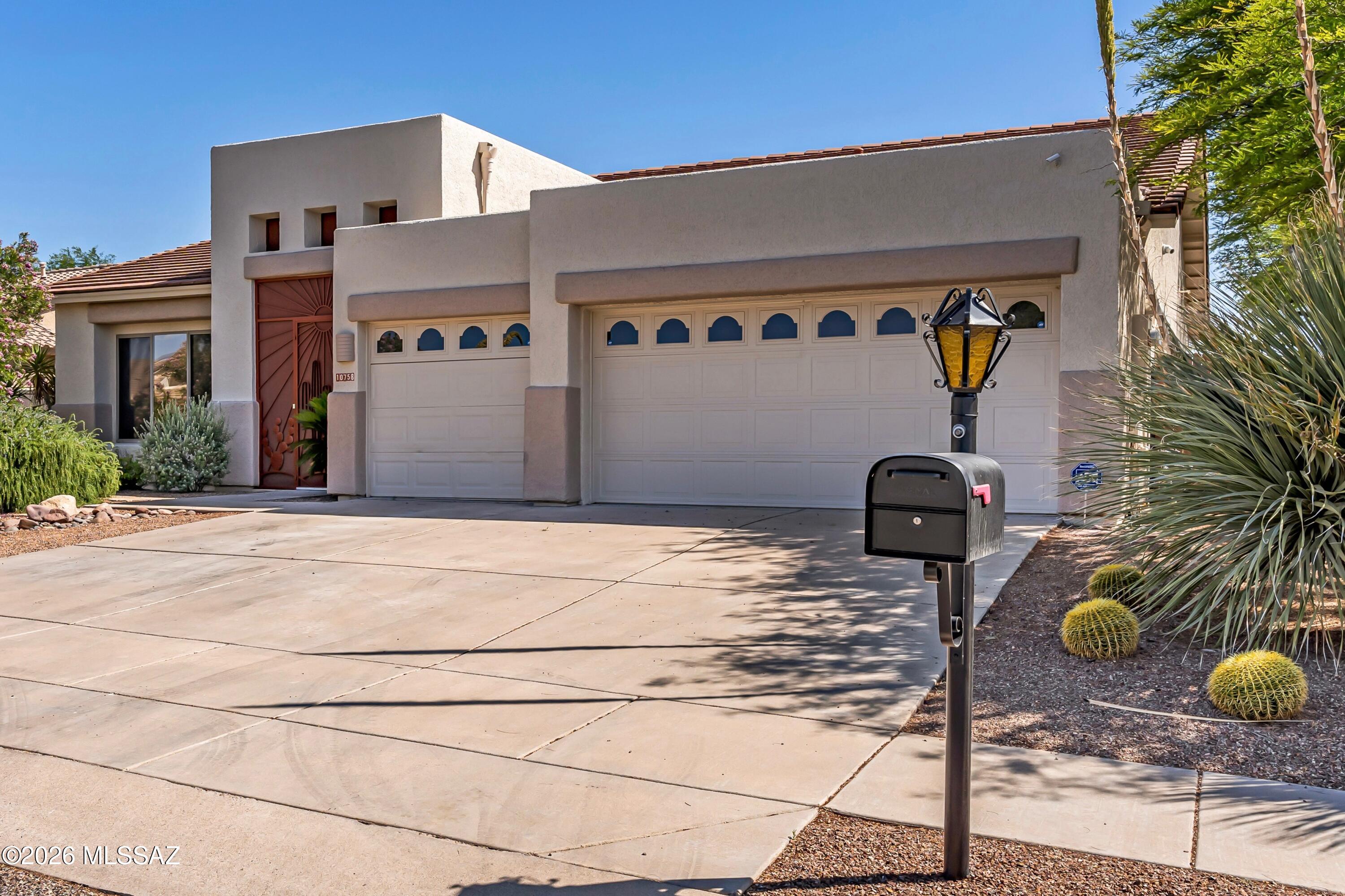 This soft Southwest contemporary home combines generous living spaces, mountain vistas, and mature desert surroundings in a tranquil east side setting.  
Designed for comfortable everyday living with no interior steps, a flexible open plan, and a spectacular yard.
The layout includes three bedrooms, two bathrooms, and a spacious den that could function well as a home office, media room, or play space. Ten-foot ceilings and expansive windows bring in abundant natural light, while neutral finishes and no carpet create a clean, cohesive interior.
At the center of the home, the kitchen features a gas range, quartz countertops, and a breakfast nook positioned to take advantage of the surrounding panoramic mountain views. A large combination living and dining room provides flexibility for entertaining, while the gas fireplace adds warmth and architectural presence to the main gathering space.
The primary suite includes a walk-in closet and a spacious bathroom with dual sinks, vanity area, garden tub, separate shower, and private toilet room. A dedicated laundry room and three-car garage add everyday practicality.
Outdoor spaces are designed for year-round enjoyment, with a screened entry porch, screened rear porch, lap pool, water feature, and mature vegetation creating a private desert setting that balances openness with shade and texture.
With its blend of functional design, natural light, and indoor-outdoor connection, this home offers a relaxed approach to Tucson living in a setting that feels both peaceful and accessible.