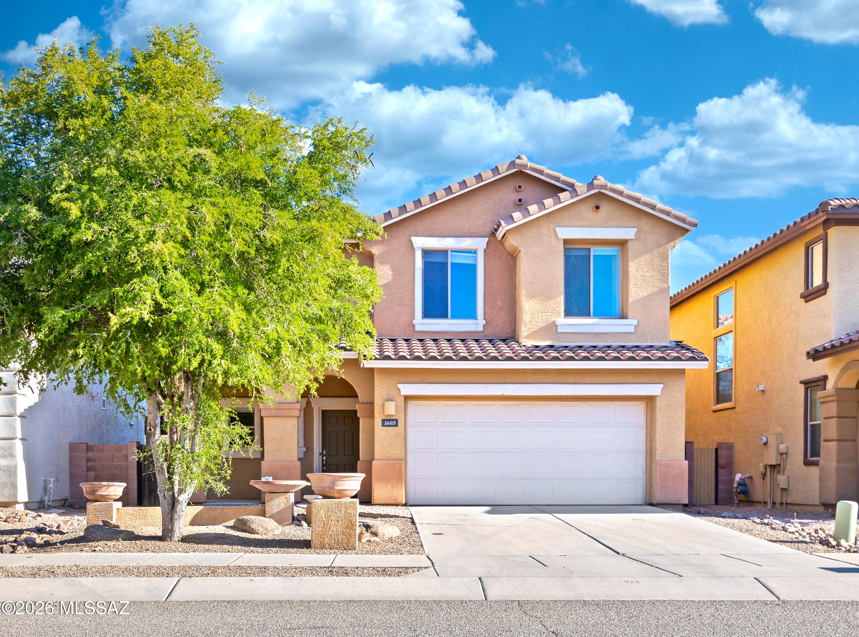 This stunning former model home in the desirable northwest community offers move-in ready living with thoughtful upgrades and an unbeatable location. Built in 2006, this contemporary two-story residence features approximately 1,560 sq ft of comfortable living space on a low-maintenance 0.08-acre lot. Complete with 3 bedrooms, 2.5 bathrooms plus a versatile loft/flex room. Step inside to upgraded porcelain tile flooring throughout the main living area, a beautiful upgrade from the original model home finishes that adds modern elegance and durability. The open floor plan is perfect for everyday living and entertaining, with a spacious great room, generous kitchen, and plenty of natural light. Upstairs you'll find three bedrooms including a primary suite with walk-in closet, plus a full bath and convenient laundry area. Outside, enjoy the fully landscaped backyard complete with a built-in BBQ and natural wood burning fireplace, ideal for weekend gatherings and outdoor dining. Additional features include a spacious 2-car garage and covered patio.  Prime central Tucson location is just minutes from shopping, schools, the River Park, the Loop, and I-10. Priced to sell, this former model home shows pride of ownership and offers fantastic value in a highly sought-after northwest Tucson neighborhood. Don't miss your opportunity to own this gem!