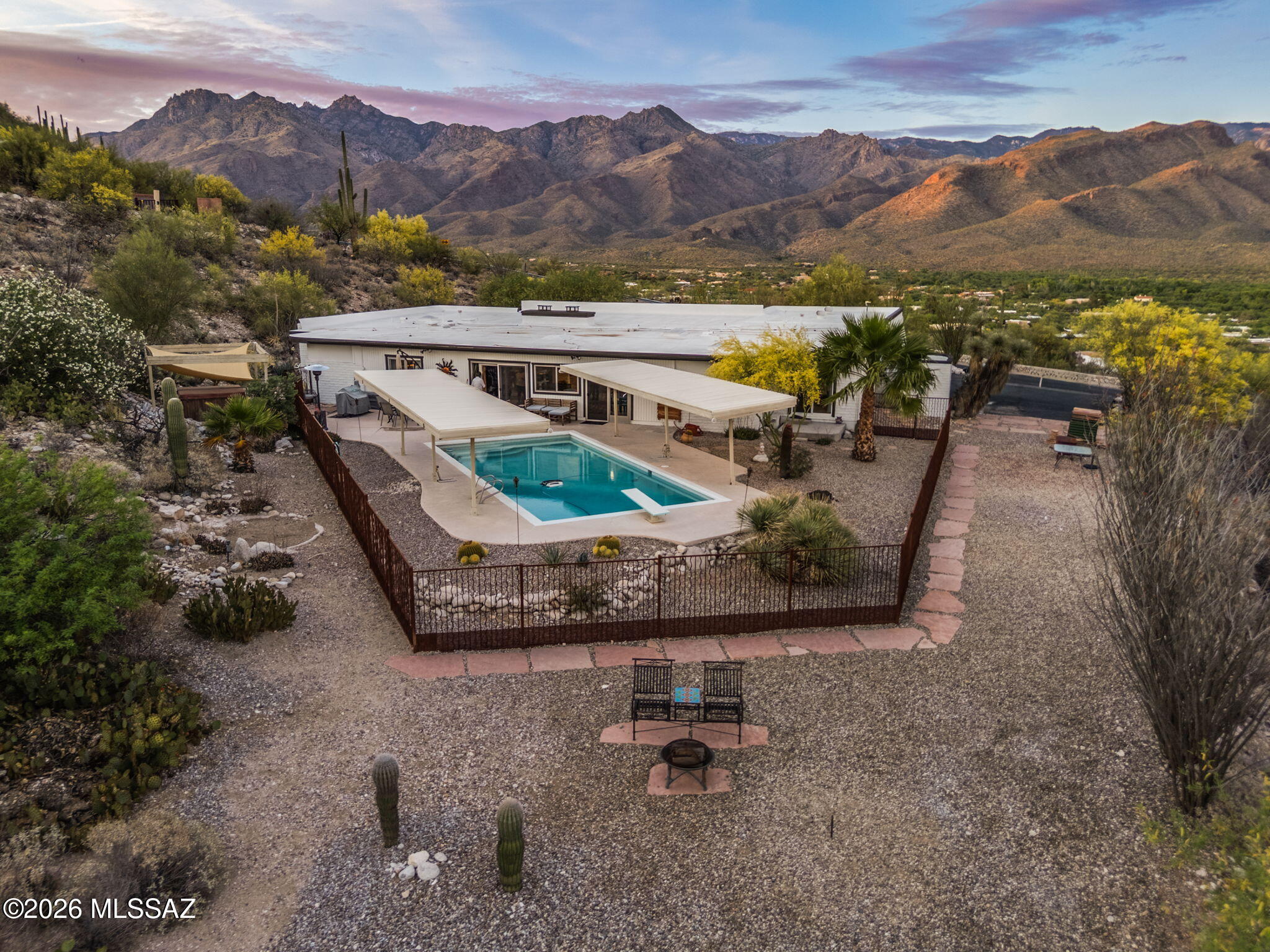 Perched above Canyon Ranch on more than an acre, this Catalina Foothills retreat captures sweeping mountain vistas by day and sparkling city lights by night. Whether you're entertaining beside the pool or enjoying a quiet Arizona sunset, this home offers the privacy, views, and lifestyle that make the Foothills one of Tucson's most coveted addresses. It is 3409 sqft with 4-beds, 2-baths, a freshly painted exterior, NEW roof, two NEW HVAC units, and a NEW tankless water heater make this a trouble-free home for decades to come. There are two fireplaces, and the primary suite has 2 walk-in closets. Cool decking & poolside Ramadas provide shelter from the sun. AZ Room is heated and cooled. 2-car garage with RV parking.