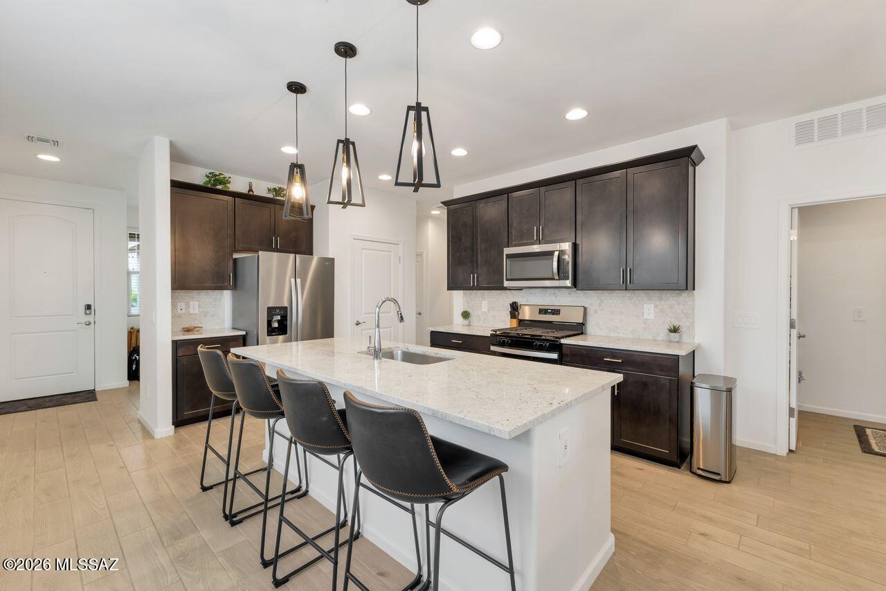 Welcome to this stunning 2025-built home in the highly desirable Hanson Ridge community of Vail, Arizona. Offering 1,602 sq. ft., this thoughtfully designed 3-bedroom, 2-bath residence showcases a modern, open-concept floor plan that truly shows like a model home.
Step inside to discover a versatile front flex space--perfect for a home office, den, or creative studio--leading into a bright and inviting living area. The gourmet kitchen is a standout feature, complete with rich walnut-colored cabinetry, sleek quartz countertops, stainless steel appliances, and a gas range, ideal for both everyday living and entertaining.
The spacious primary suite offers a private retreat with dual vanities and a beautifully appointed bath, while the additional bedrooms provide comfort and flexibility for family or guests. Enjoy Arizona living at its finest in the beautifully landscaped backyard, designed for relaxation and entertaining, with no neighbors behind--providing exceptional privacy and serene desert views. Located in a sought-after neighborhood known for its charm and community feel, this home is truly better than new and move-in ready.