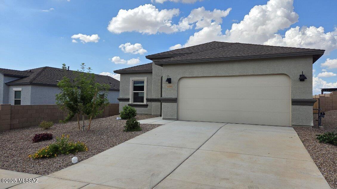 This home is TO BE BUILT, on a beautiful corner lot! Snuggled within the serene surroundings of Sycamore Vista, The Baxter offers a blend of comfort and convenience, making it a perfect fit for modern living. Spanning 1,423 square feet, this thoughtfully crafted single-story home features three bedrooms, two bathrooms, and a 2 car garage, all within the picturesque foothills of the Santa Rita Mountains.
As you step onto the welcoming front porch and enter through the foyer, you're greeted by a spacious and open floor plan that flows effortlessly into the heart of the home. The great room is designed for both relaxation and socializing, seamlessly connecting to the dining area and kitchen. The kitchen is a culinary enthusiast's dream, featuring sleek quartz countertops, a central island, and Shaker-style cabinetry, all designed to offer ample storage and a stylish backdrop for your cooking adventures. The adjacent pantry ensures that all your essentials are within easy reach, making meal prep both efficient and enjoyable. The primary bedroom, located at the rear of the home for enhanced privacy, serves as a peaceful retreat. It includes a spacious walk-in closet and an en-suite bathroom equipped with dual vanities and a luxurious shower. The two additional bedrooms are thoughtfully positioned near the front of the home, sharing a full bathroom, making it ideal for families or guests. Outdoor living is a key feature of The Baxter, with a covered patio that extends from the dining area, offering the perfect space to enjoy Tucson's stunning sunsets or host a weekend barbecue. Living in Sycamore Vista means you're part of a community that values both convenience and quality of life. Each home in this community comes with beautifully landscaped front yards, equipped with auto drip irrigation systems and soft water loops, enhancing the beauty and functionality of your outdoor space. Additionally, Sycamore Vista homes are energy-efficient, featuring DOE Zero Energy Ready standards, including spray foam insulation, tankless water heaters, and LED lighting throughout, ensuring lower energy costs and a reduced environmental footprint. The community's higher elevation not only offers cooler summer temperatures but also less light pollution, making it a perfect spot for stargazing. Sycamore Vista is ideally located near top-rated schools in the Vail School District, including Sycamore Elementary and Corona Foothills Middle School, making it an ideal choice for families. Beyond the tranquility of home, outdoor enthusiasts will appreciate the proximity to local state and national parks, including Coronado National Forest and Colossal Cave Mountain Park, offering endless opportunities for hiking, biking, and exploring Arizona's natural beauty. The community's location also provides easy access to shopping, dining, and major employers like the Target Distribution Center and the Amazon Fulfillment Center, ensuring that everything you need is within reach. Experience the best of Arizona living at Sycamore Vista, where The Baxter offers the perfect blend of modern amenities, quality craftsmanship, and the natural beauty of the Santa Rita Mountains, creating a place you'll be proud to call home.