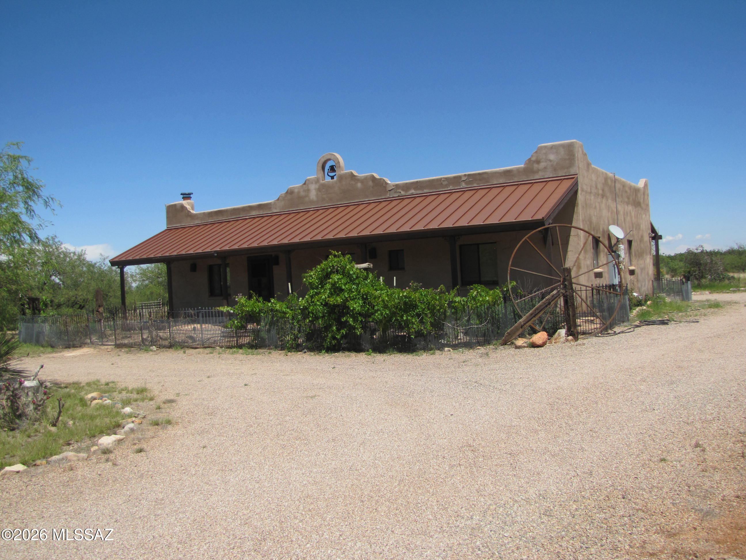 Located in a very sought-after area, this Santa Fe style 3BR/2Ba home has much to offer:  Amazing views of the Coronado National Forest and Dragoon Mountains, covered deck in front & back, open floorplan with wood burning FP in living room, French doors from dining area/kitchen to back deck. kitchen island, new carpet, roll-in shower, detached extended length 2-car garage with high ceiling & 2 workshop/office areas, owned solar system that credits back to electric company, solar hot water heater, shooting range, located at the end of the road giving more privacy, 1/3 well share, spacious 9+ fenced acres, grape vines in fenced courtyards, mature landscaping. Private country living yet only 2 miles off paved road with easy access to I-10 and Hwy 191. Come check out this remarkable property!