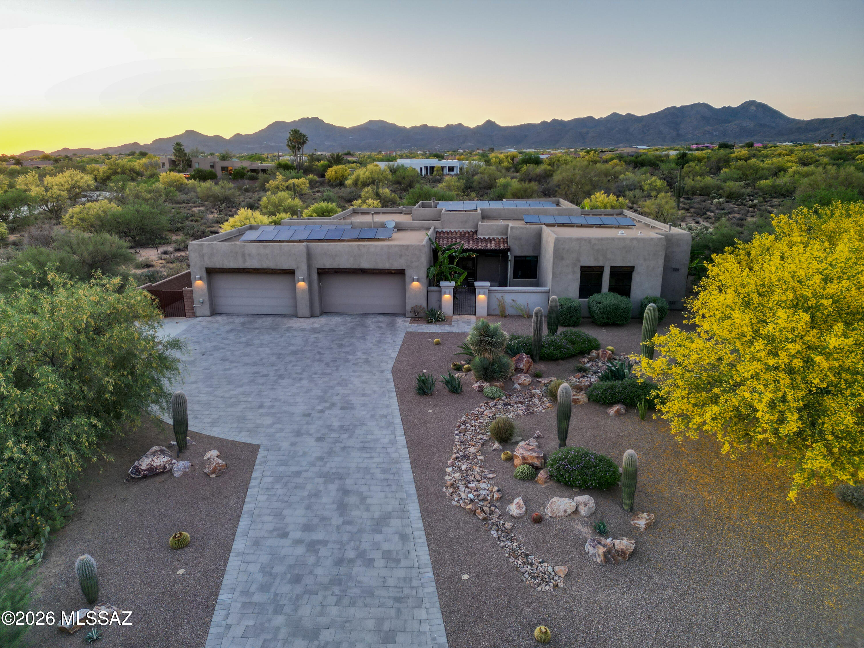 Gorgeous contemporary Oro Valley Home with all the bells and whistles. Integrated smart features throughout. Upgraded indoor - outdoor premium sound system ($15k) integrated within the home and controlled by a tablet. Top of the line Monogram appliances with smart technology featuring wifi connectivity and app (remote) monitoring. Open floor plan with neutral colors, 12ft ceilings with niches and tray ceilings throughout the home and top-of-the-line materials. Window covering on large picture windows in the great room are remote controlled with multiple opening settings. Custom storage throughout the home by Closet Trends. Sightless solar panels were added to the home approximately three years ago - which cuts the electric bill by 60% throughout the year. Gorgeous contemporary Oro Valley Home with all the bells and whistles. Integrated smart features throughout. Upgraded indoor - outdoor premium sound system ($15k) integrated within the home and controlled by a tablet. Top of the line Monogram appliances with smart technology featuring wifi connectivity and app (remote) monitoring. Open floor plan with neutral colors, 12ft ceilings with niches and tray ceilings throughout the home and top-of-the-line materials. Window covering on large picture windows in the great room are remote controlled with multiple opening settings. Custom storage throughout the home by Closet Trends. Sightless solar panels were added to the home approximately three years ago - which cuts the electric bill by 60% throughout the year.

Central vacuum throughout the home including the garage and workshop space.

Highly desirable and hard to find climate controlled and insulated 4-car garage ($20k upgrade for insulation) that has an additional 300 sq ft (approximately) of storage/workshop area. Also includes cabinets and countertops built out by Closet Trends. The garage includes a 50 amp Tesla charger and industrial ice maker.
A portion of the garage could be used for your home gym, pilates studio, man cave, workspace or custom tailored to your own personal needs.

The front yard is beautifully landscaped with desertscape matching the other 26 homes in this beautiful neighborhood. The medium-sized courtyard showcases the morning sunrise over the Catalinas and is ready for the new owners to put their personal touches on it.

The home beautifully transitions from indoor to outdoor living with your own private oasis where neighboring homes are out of sight. Gorgeous resort-style pool with 4 bar stools and sun shelf seating and umbrella area. The pool is self cleaning and comes with a custom-colored light system controlled by your phone. As mentioned earlier, top-of-the-line sound system and a large television for those who don't want to miss the big game. The pool area has six gas lines installed and ready to go for fire pits and/or tiki torches. There's an additional gas hookup for a BBQ grill. Also has a very large covered patio area that has an additional extendable electronic shade for even greater coverage. A large desert buffer sits behind the home with unobstructed desert views. Both front and backyard drip systems are on timers. There is a water trough behind the open steel fence also on a drip system for those who would like to get a glimpse of the local wildlife in the peaceful mornings or scenic evenings (deer, javelinas, quails, bobcats)

The subdivision features a community park and fenced dog park. Being in Oro Valley, the home is situated within 5-10 minutes of great public and private golf courses. For bicycle enthusiasts, Oro Valley is connected to the Chuck Huckleberry Loop - a 137 mile car-free paved trail system that connects Oro Valley, Marana and Tucson for bikers and runners alike. Oro Valley is also one of the top spots in the country for stargazing. Because of the town's strict ordinances on light pollution and observatories located nearby, constellations, planets and even the Milky Way are visible to the naked eye.