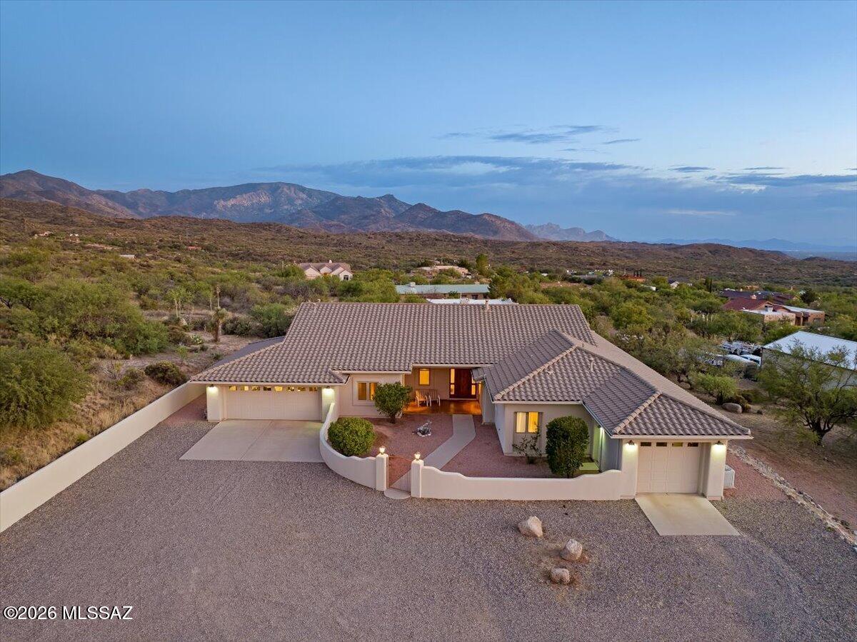 Tucked into one of Oracle's most desirable custom home neighborhoods, on a peaceful no-through road, this first-time-on-market retreat blends rural luxury with serene desert living. Set on 1.5 private acres with breathtaking mountain views & NO HOA, this lovingly maintained home offers the perfect balance of comfort, space, & serenity. Inside, soaring ceilings create an airy, inviting feel, while a stunning dual-sided fireplace creates warmth & ambiance between the dining & family rooms-the perfect centerpiece for cozy evenings or entertaining guests. Thoughtful updates, including a new HVAC system, water heater, dishwasher, & refrigerator, make everyday living easy. The spacious layout is designed for both quiet mornings & lively gatherings, with natural light pouring in from every angle. Outside, enjoy the beauty of the high desert with mature landscaping, French drains for added functionality, and room to truly breathe. Two attached garages provide abundant space for 3 vehicles, hobbies, or outdoor toys. Whether you're sipping coffee while watching the sunrise over the mountains or hosting friends under Arizona's star-filled skies, this property captures the magic of Oracle living with privacy, charm, & just the right touch of upscale country elegance.