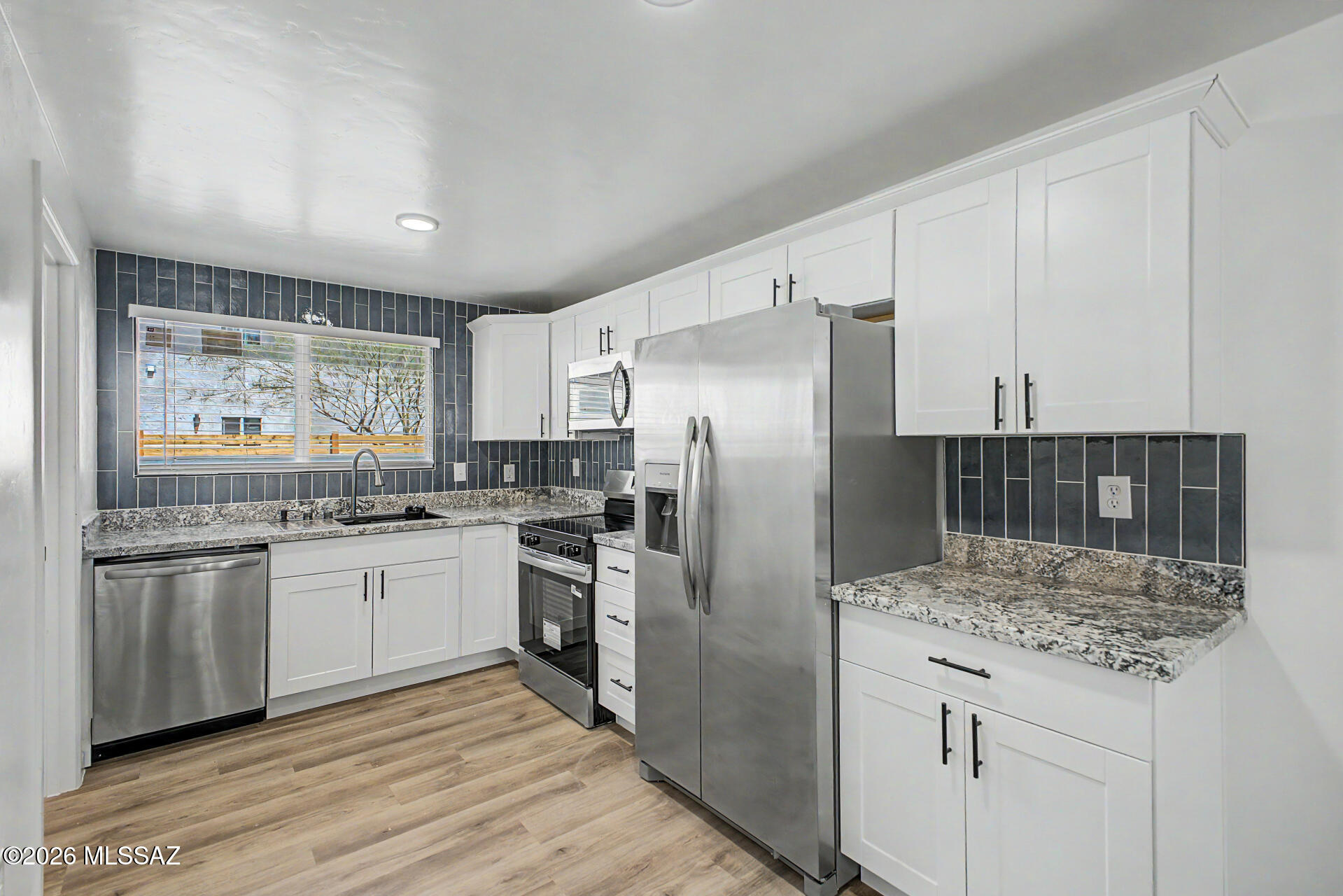 Home, sweet home! This end-unit townhome welcomes you with a low-care yard, a carport, and an attached shed for additional storage. Inside, you'll find an inviting living room with a soothing palette, recessed lighting, stylish wood-look flooring, and a cozy fireplace for intimate evenings. The eat-in kitchen comes with granite counters, white shaker cabinetry with crown moulding, a striking tile backsplash, and sleek stainless steel appliances. The main bedroom offers a private bathroom for added comfort. Unwind at the end of a long day in the backyard, complete with a covered patio, direct alley access, and ample space for outdoor relaxation. Don't miss your chance to own this one! Owner/Agent