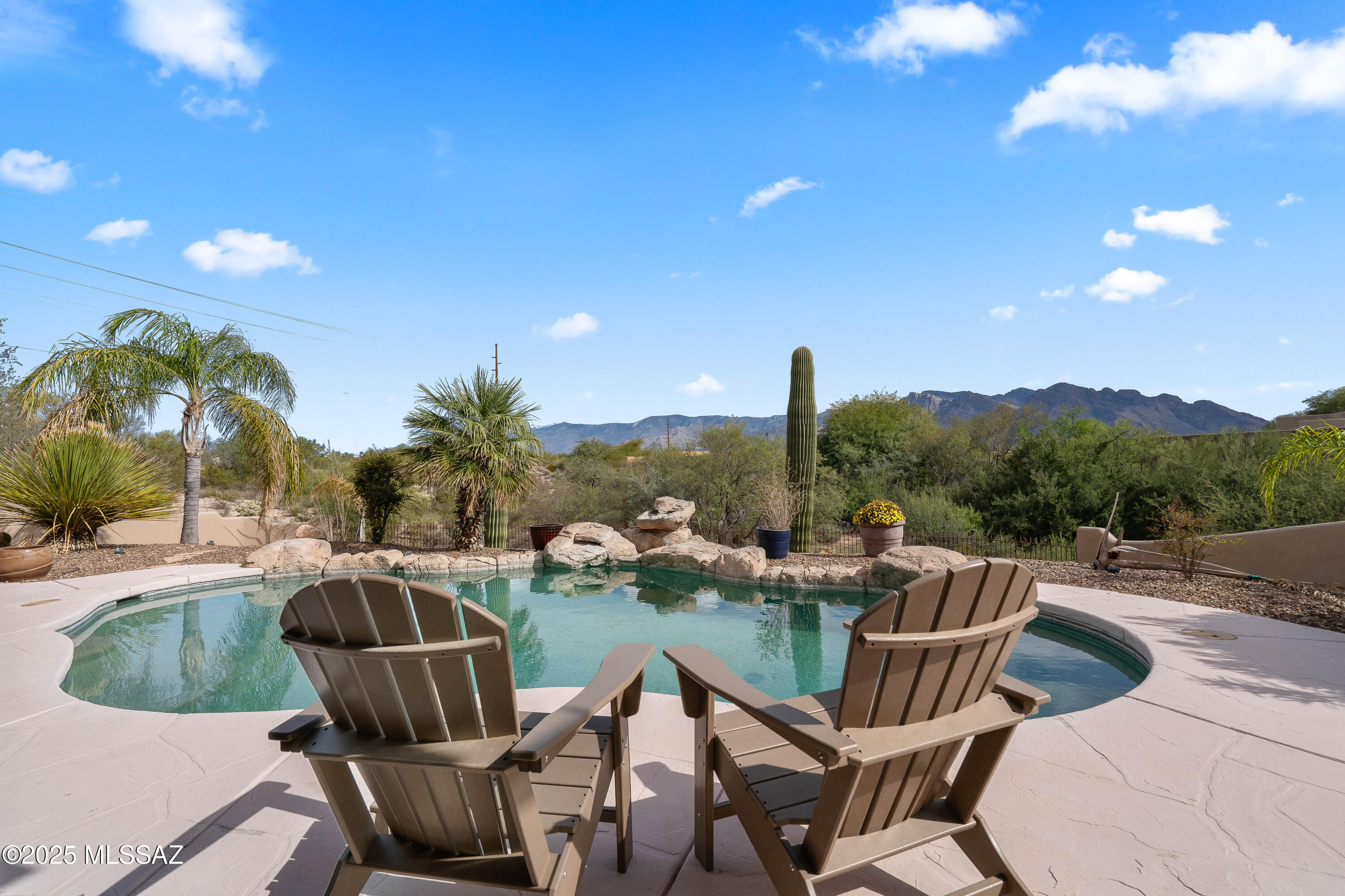 Former TJ Bednar model home with great Catalina Mountain and city views. 
This Southwestern-style home features viga beam ceilings, solid Alder doors, lighted niches, and two beehive fireplaces in the living and family rooms. 
Kitchen has a large island, breakfast bar, double ovens, 42'' Alder cabinets, wine rack, desk area, and breakfast nook.
East-facing backyard with solar-heated pool, spa, water feature, and beautiful views. Owned solar helps with energy savings!
Additional rear lot adds privacy. 
Other features include 11' garage ceiling, water softener loop, and laundry room with cabinets, counter, sink, and skylight. A great home with character, views, and space to enjoy Arizona living. Move-in ready and perfect for entertaining and everyday living in the desert.