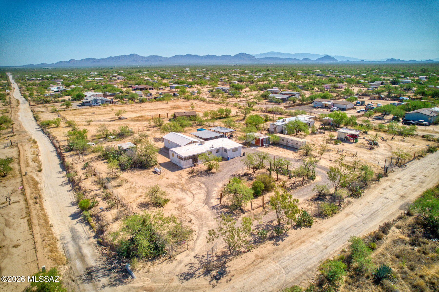 Discover the potential of this 4-bedroom, 2-bathroom property situated on a spacious, fully fenced lot with room to make it your own. Whether you're looking for an investment opportunity,  or a place to create your dream rural retreat, this home offers endless possibilities. The property features a circle driveway, three covered carport spaces with a metal roof over a concrete slab, and two large metal storage sheds providing plenty of room for tools, equipment, hobbies, or extra storage. Inside, you'll find a functional layout with a dining area off the kitchen, a pantry, gas range, and a charming wood-burning stove that adds character and warmth. Bring your vision and creativity to unlock the full potential of this property and enjoy the space, privacy, and versatility that the land provides.