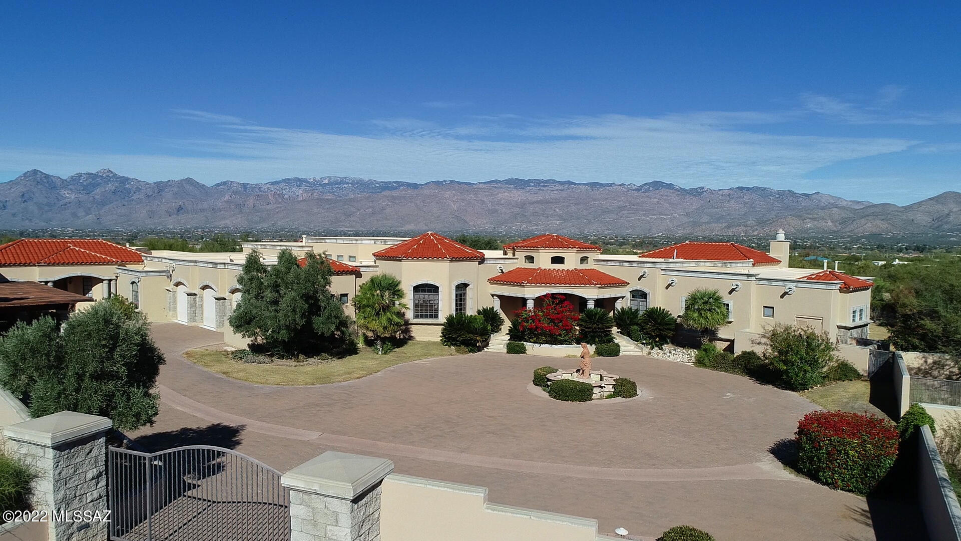 Panoramic views of the Rincon and Catalina Mountains. This private gated Spanish Mediterranean Estate situated on a 3.3 Acre lot within the Wild Horse Ranch Estates - Enter thru a long circular cobblestone driveway and motor court, around a water feature is just inside the gated entry. A rotunda with Cantera stone showcases a majestic entrance that has a wall of windows looking north to the Catalina Mountains. A beautiful estate with 8,753sqft., with a 2-bedroom guest casita attached to the main house offers a separate entrance featuring a full bathroom, kitchenette, a gas fireplace, a living room/dining room. Magically designed with a Media room, rec/game room, Den/Office, Family room, Living room, Library, Exercise room, a separate underground Wine Cellar. Car enthusiasts will appreciate the oversized, 3-vehicle garage featuring an epoxy floor, storage and bonus room are attached to the main house. There is also a detached, 12-vehicle garage, a 4-vehicle carport with acres of concrete pavers. The gourmet kitchen "A chef's dream" features a granite covered island is the focal point as a gathering space for friends and family. A family sized granite table is included in the eat-in kitchen. Custom cabinetry, Stainless steel appliances include a built-in sub-zero refrigerator and a 6-burner gas cook top with a custom vent hood.
Huge master suite with Cantera stone gas fireplace. A private patio, coffered ceilings and a built-in entertainment center are also included. Separate granite-capped vanities, a steam shower and a garden, jetted tub are features in the exquisite master bathroom. Large his and her walk-in closets with Alder wood built-in accessories are included. This custom home features: Alder wood interior doors, 24-inch Travertine tile thru out the home except in the bedrooms. Decorative masonry fencing accents the very impressive resort style outdoor lap pool with elevated spa, fountain, lagoon, and ramada. Travertine tile surrounds the pool area and ramada which includes a BBQ and sink. A second, in-door house pool allows swimming against jets for an invigorating workout. REO Property Sold AS-IS. *All information contained in this listing, including square footage, has been provided as a courtesy and is not guaranteed. Buyer is solely responsible for verifying all information herein to his or her satisfaction, obtaining independent measurements and appraisals as necessary.