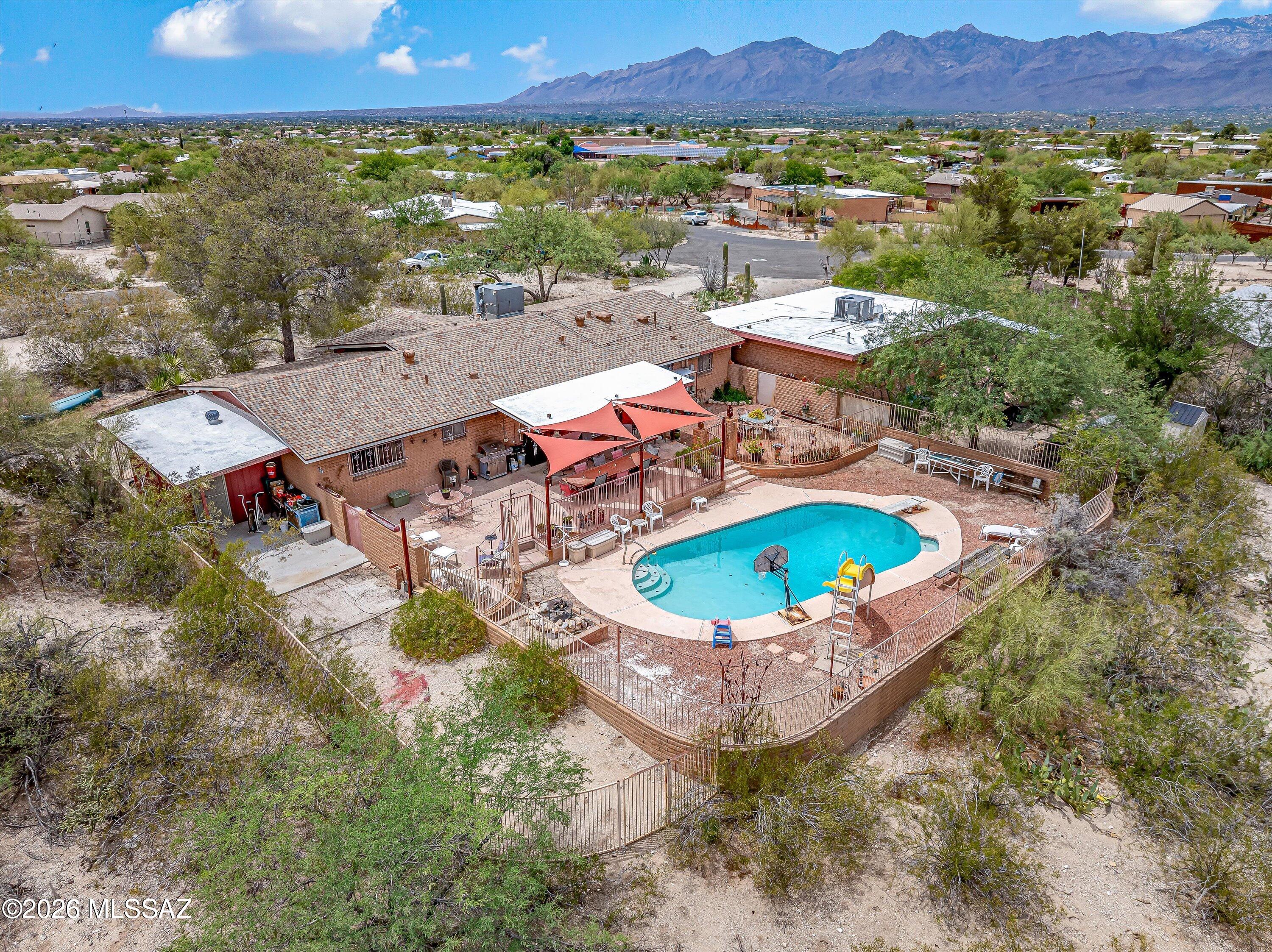 Lovingly owned for 43 years, this awesome east-side property situated on .82 acres with panoramic mountain views is ready for it's new owner! 4 bedroom/2 bath main house with a spacious 1 bed/1ba guest house w/ its own laundry room-ideal for guests, multi-generational living or rental potential. 
Backyard designed for outdoor enjoyment, complete with a sparkling pool, covered patio and stunning mountain vistas. 
Interior features tile flooring throughout, great room w/ fireplace, spacious kitchen with ample counter space, and a formal dining room. Several large arched picture windows and exposed brick interior walls add to the charm and character of this custom home. Large attached storage room. Best of both worlds- peaceful desert home yet close to schools, shopping and cinema! No HOA!