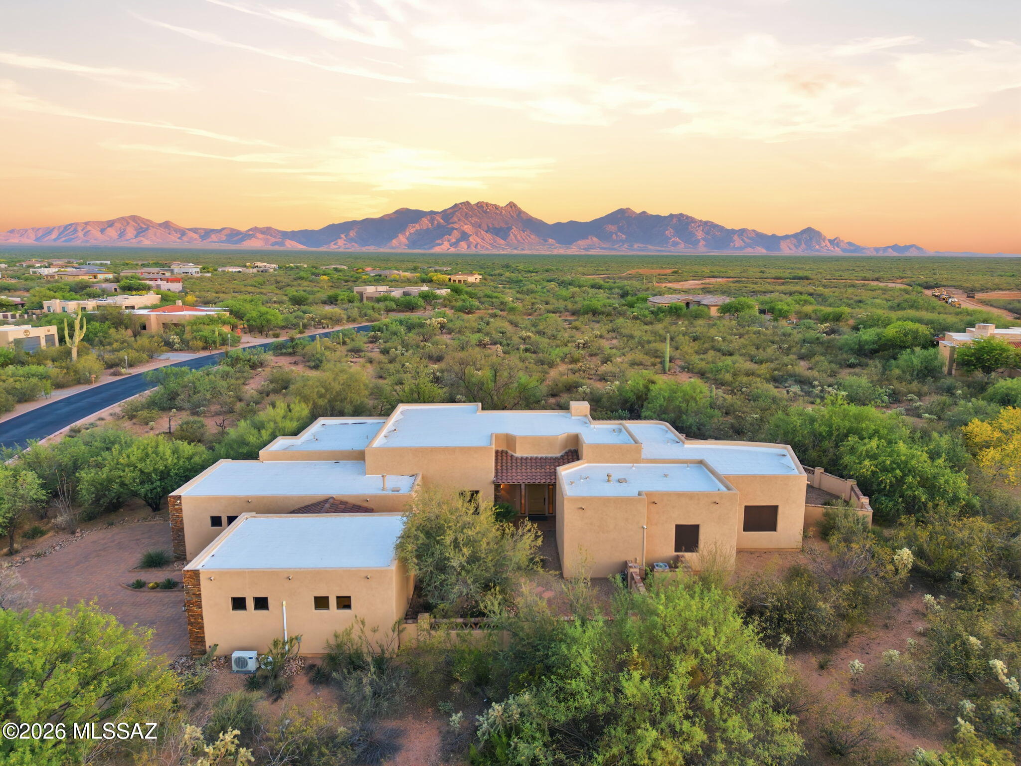 Set against a backdrop of sweeping desert & mountain views, this exceptional property offers the kind of space, privacy, & quiet beauty that defines true Arizona living. Tucked away on a generous homesite, the home unfolds with a seamless blend of indoor comfort and outdoor serenity--where mornings begin with soft desert light & evenings gather around the fire pit under wide open skies. A private front courtyard welcomes you in. Inside, the open-concept design creates an effortless flow between the living, dining, & kitchen areas, all anchored by expansive windows that frame the natural landscape beyond. The chef's kitchen features granite countertops & rich knotty alder cabinetry, carried throughout the home for a warm, cohesive feel. The formal dining area & family room are enhanced by a coffered ceiling, adding architectural depth and character. Polished travertine tile--professionally cleaned, sealed, and finished with refreshed grout--flows throughout the main living areas, paired with matching travertine baseboards. Throughout the home, 8-foot interior doors are framed with detailed wood trim and custom accent corner details, adding a refined architectural touch. The heart of the home is warm and inviting, designed for connection, whether hosting guests or enjoying a quiet night in. All four bedrooms offer comfort and retreat, enhanced by brand new lush carpeting that brings a fresh, luxurious feel underfoot. The primary suite is a true sanctuary--spacious and serene, with peaceful views and direct outdoor access, featuring a jetted soaking tub, makeup vanity, and elegant vessel sinks for a private retreat at day's end. Step outside and you'll find multiple covered patio spaces designed for year-round enjoyment, supported by striking stone columns and rich wood beams. The backyard offers a perfect balance of relaxation and recreation, with room to entertain, play, or simply soak in the surrounding beauty. Car enthusiasts will appreciate the rare 4-car garage setup with two separate 2-car garages, one of which is fully upgraded with an epoxy-coated floor, painted interior, and an 18K BTU mini-split system for heating and cooling--currently used as a home gym. Additional improvements bring peace of mind and efficiency, including a recoated roof (May 2023), new bug screens on all windows, solar screens on select west-facing windows, new exterior door seals, and a 5-year termite treatment completed in June 2024. This is more than just a home--it's a place where comfort meets craftsmanship, where every upgrade has been considered, and where the surrounding landscape becomes part of your everyday living experience.