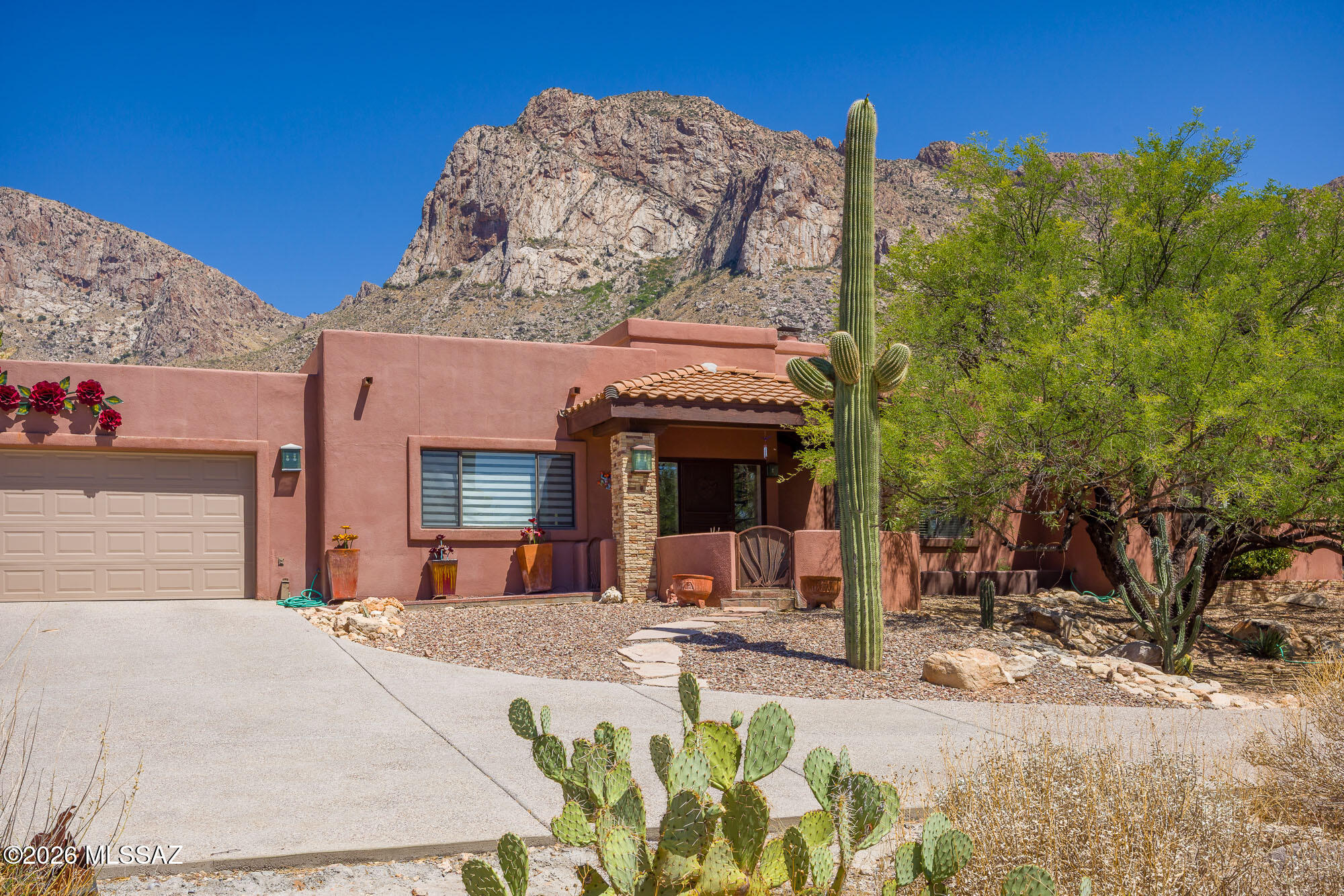 Breathtaking views of Pusch Ridge nestled on a rare private 1.12 acre lot w/ NO HOA. This exceptional 4BR, 3 BA residence offers 4,035 SqFt. Charming courtyard welcomes you. This spacious chef's kitchen features granite c-tops, Wolf gas cooktop & oven. Newer dishwasher & microwave w/abundant prep space. Eat-in area perfect for casual dining. A convenient pass-through window opens to the dining/bonus room. The spectacular great room has new Anderson windows that captures more amazing views. A two-way fireplace connects to a stunning library with custom built-ins. The primary suite has been beautifully refreshed with new tile and paint & his/her walk-in closets. The completely remodeled primary bath features dual farmhouse sinks, free standing soaking tub & oversized walk-in shower Step outside to a wonderful entertaining backyard with close up panoramic views of Pusch Ridge. Multiple patios with a sparkling pool and built in BBQ. Custom landscaping and new irrigation system. Additional improvements include newer HVAC(2022), roof recoated (2025). This private home is located in the heart of Oro Valley close to all amenities.