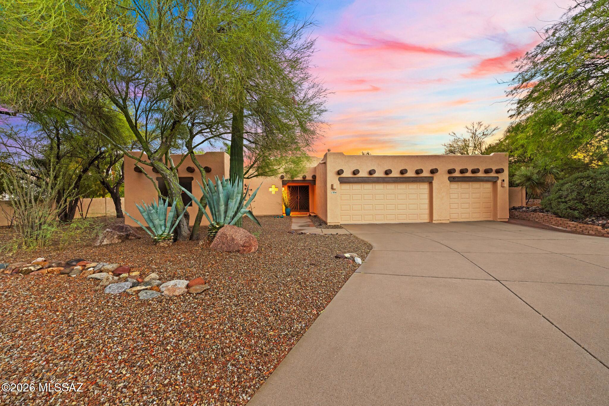Santa Fe architecture paired with a resort-style backyard makes this home truly stand out! Situated on a nearly ½-acre lot in the desirable Oro Valley, this home blends character & comfort. The oasis-like backyard features lush landscaping, citrus trees, built-in BBQ, sparkling pool & spa with UV disinfection system. Backing up to a well vegetated wash for privacy & breathtaking sunset views! Inside; soaring ceilings, wood accents, solar tubes & a classic beehive fireplace create a warm, inviting feel. The bright kitchen with black newer SS appliances opens to the great room & dining area. Split floorplan with 3 bedrooms, 2 baths & a 3-car garage. Newer HVAC! Recent exterior/Interior paint. Updated Primary shower! Community amenities include sand volleyball & picnic area.
