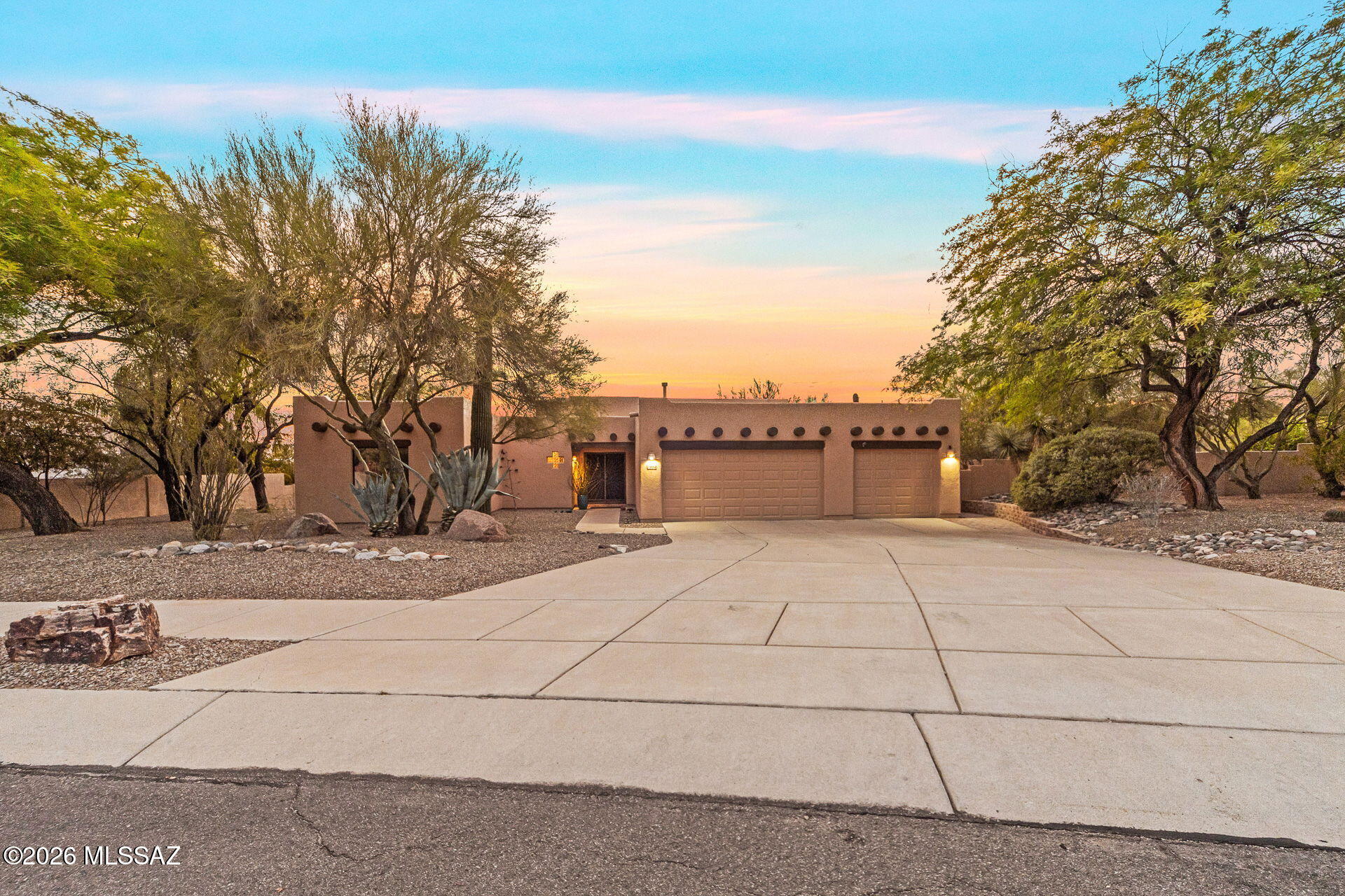 Santa Fe architecture paired with a resort-style backyard makes this home truly stand out! Situated on a nearly ½-acre lot in a desirable Northwest/Oro Valley location, this home blends character & comfort. The oasis-like backyard features lush landscaping, citrus trees, a built-in BBQ, sparkling pool & spa with UV disinfection system. breathtaking sunset views. Backing up to a well vegetated wash for privacy & breathtaking sunset views! Inside; soaring ceilings, wood accents, solar tubes & a classic beehive fireplace create a warm, inviting feel. The bright kitchen with black SS appliances opens to the great room & dining area. Split floorplan with 3 bedrooms, 2 updated baths & a 3-car garage. Leased solar offers energy savings. Community amenities include sand volleyball & picnic areas.