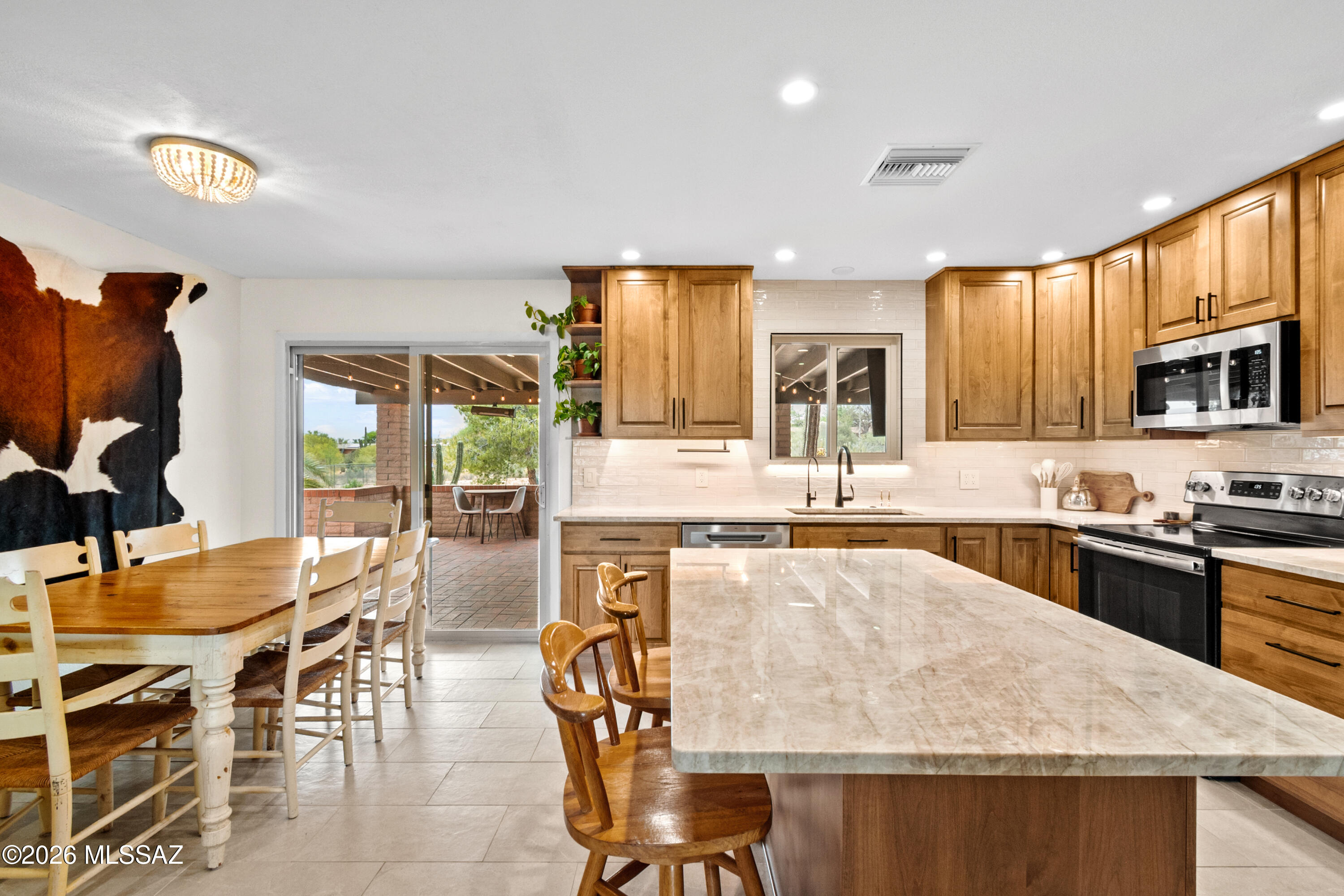 Multiple offers received - Seller will be reviewing 5/4 by 5:00pm Range Pricing: Seller will accept or counter offers between $430,000-$440,000. Nestled in the sought-after heart of Oro Valley, this stunning updated 3-bedroom, 2-bath home sits on a private .88-acre lot. The fully remodeled kitchen features Taj Mahal quartz countertops, a large island with eat-in bar, floor-to-ceiling cabinetry, reverse osmosis system, stainless steel appliances and a seamless flow into the dining and main living areas with new tile flooring and baseboards. Step outside to an expansive covered patio designed for entertaining, complete with string lights and a mounted TV, perfect for barbecues, gatherings, or relaxing evenings enjoying the breathtaking AZ Sunsets. Enjoy all that Oro Valley has to offer with Space for RV parking and all your toys, the oversized yard provides endless potential to design your dream outdoor retreat. Recently paved driveway, HVAC system less than 3 years old, and much more.