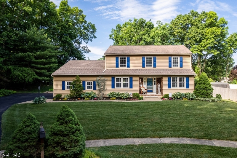 Welcome to this impeccable 4-bedroom, 2.5-bath Colonial nestled on a cul-de-sac in desirable Succasunna. A covered front porch and paver walkway lined with flowering perennials create a warm welcome. Set on a beautifully landscaped, level property, this home offers the perfect blend of comfort, style, and functionality. Inside, hardwood floors, crown molding, chair rails, and wainscoting add timeless charm. French doors open to the formal living room adjacent to the spacious dining room. The updated kitchen features abundant cabinetry, granite, stainless steel appliances and a breakfast bar overlooking the family room with a floor-to-ceiling brick gas fireplace. Sliders lead to a large deck overlooking the picturesque private, tree-lined backyard. A lighted paver walkway connects to a patio with custom blue-flagstone seating and fire pit, creating an ideal outdoor retreat. An updated powder room (2021) and laundry room with newer W/D complete the first level. Upstairs, 4 spacious bedrooms feature refinished hardwood floors. The primary and main baths were beautifully renovated (2024) with porcelain tile, marble and stylish finishes. The finished basement provides add'l living space with a rec room, kitchenette area, workshop and storage room. Additional highlights include a two-car garage with attic, central air, natural gas and public utilities. Conveniently located near Rt 80, 46, 10, and 206, NJ Transit, shopping, dining, schools, and the Horseshoe Lake Recreation Complex.