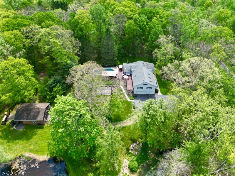 Does your dream home include a picturesque pond, stream and large barn? Would an enormous primary suite with a sunny office, full bath, soaring ceilings and lots of natural light be ideal? What about privacy and proximity to state and federal land? YOU CAN HAVE IT ALL in this rambling 4 bedroom, 3 full bath home set on three acres. Thoughtfully added onto over time, this home is full of character and possibilities. A stunning sunroom serves as a perfect retreat in all kinds of weather. The well equipped kitchen is open to the family room and dining room, each with a wood stove for cozy nights in. The living room boasts high ceilings and a gas fireplace set in beautiful stonework, surrounded by built in shelving. Perfect for entertaining, an in-ground pool is accompanied by a screened-in party room with electric and plenty of room to eat, lounge and enjoy. The multi level deck with hot tub offers direct convenient access to a full spa-style bath. The two car attached garage and large pole barn suit many needs. A blue stone patio, set next to the stream, invites you to enjoy all that nature has to offer. Finished basement rooms offer many possibilities for hobbies, storage and more. Lots of potential exists to convert a section of the home into an in-law suite with its own entrance. A true retreat away from the hustle and bustle of the world awaits you. Near to fishing, hiking and all that country living has to offer. Welcome home!