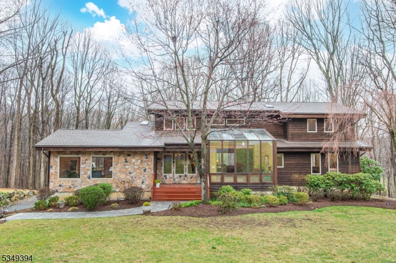 Welcome to this one-of-a-kind, custom-built Lindal Cedar Home, where architectural design meets natural beauty. Nestled on nearly 3 acres of private, wooded lot, this Post & Beam construction home is a masterpiece of craftsmanship & sustainability. Designed with large expanses of windows, the home brings the outside in, offering panoramic views that stretch across the lush landscape. The open floor plan & soaring ceilings create a sense of spaciousness, perfect for both relaxation and entertaining. As you step into the large glass-enclosed foyer, you're immediately welcomed by a breathtaking two-story stone fireplace in the living room that adds a dramatic focal point.On the main level, you'll also find a luxurious primary suite w/ 2 walk-in closets & a newly renovated (2020) spa-like bath w/ heated floors. The 2nd floor offers 3 spacious bedrooms, a full bath & balcony that overlooks the living room below.The Bright walk-out basement has potential for an in-law suite w/ large windows, a full bath, and closet space.Lovingly cared for by the current (2nd) owner, other recent updates include: New ROOF & Skylights 2024, NEW Front Walkway 2024, Newly Lined POND 2024, Basement mini-split 2022, 2nd floor furnace 2023. And a Lutron Caseta home automated system. Shongum Lake Community offers access to a clubhouse, beach, boating, swimming, and a full calendar of social events.