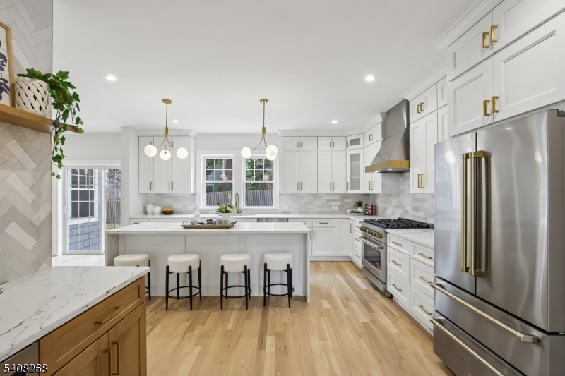 One-of-a-kind dream home in the heart of Maplewood with incredible access to vibrant village shops and restaurants and NYC trains. Thoughtly reimagined from top to bottom to offer exceptional living space across 4 finished floors. New hardwood flooring, custom millwork and modern lighting set the stage for a versatile flowing floorplan that will check every box. The incredibly spacious chef's kitchen has been outfitted with professional grade appliances, quartz counters and oversized island with a waterfall edge, Kraus workstation sink, and convenient servery with built-in beverage fridge. Formal living room and dining rooms, each with designer lighting, a family room with fireplace, stylish half bath and convenient mudroom with bench and access to the garage complete this level. Upstairs, find huge light filled bedrooms, full baths, a sitting room/den and full sized laundry room. The primary bedroom is a private retreat with custom millwork and 2 custom walk-in closets, but the luxury hotel inspired marble bath will dazzle you with double vanity, soaking tub, large galss enclosed shower and private bidet toilet fixture.The finished lower level with half bath and a pretty fenced backyard with patio offer additional spaces to unwind and relax. New low maintenance siding, new roof, new landscape, new Clopay garage doors with smart door openers by Liftmaster, new HVAC, new LED lighting, newly paved driveway, new thermal windows, and so much more. You will not want to miss this!