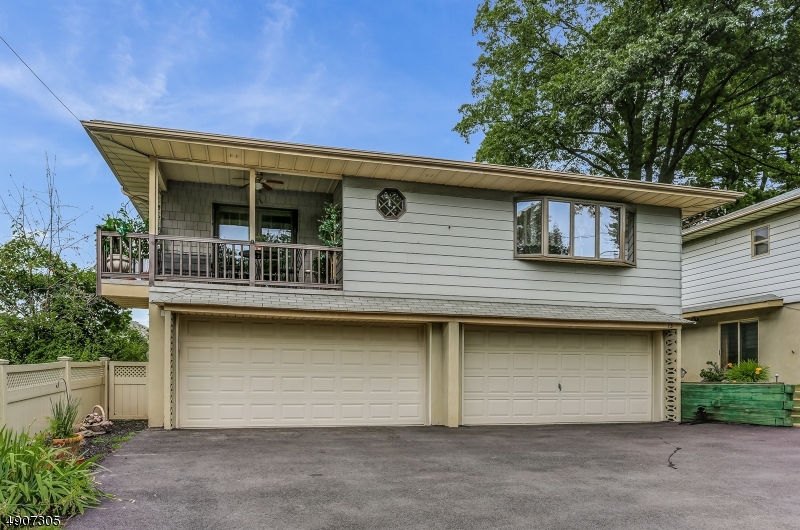 So many possible ways to enjoy this home. Perfect for multi generational use with separate entrance, full bath & living area on ground floor. Parking for 9 cars & 4 car heated garage for car buff or a business owner who needs storage space or parking for extra vehicles. Kitchen w/granite, huge center island w/cooktop & downdraft ventilation system & double electric wall ovens.  Large window Lets in natural light.  Kitchen flows to living rm w doors to veranda. Ktichen & Living Rm open to Dining Rm 18x11.  The ground level Fam Rm has wet bar & a wd burning fplc w/Heatolater. ground also has large laundry rm  The 2nd flr has 3 beds & 2 bths.  The mster bed has full bth & w in closet.  Hdwd floors abound. Lovingly cared for. 2 blocks from NJ Transit Bus to NYC. Very close to Rts 80, 17,46 and garden st parkway