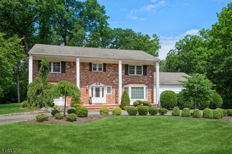 Stately Colonial home nestled on close to an acre of manicured property. From the architectural details, hardwood & marble flooring& spacious rooms to the stunning kitchen & finished lower level, this home is designed for comfortable living & entertaining. A semicircular driveway & beautifully manicured front yard invite you inside to a large, bright foyer w/a stone accent wall, graceful staircase& a powder rm. The spacious LR  includes a bow window & French doors opening to the FR. Get cozy around the double side corner fireplace set in a warm brick surround. Off the FR is a lovely sunroom, overlooking the deep & private back yard. The generous formal DR is perfect for hosting a crowd or just a few in elegant comfort. The gourmet eat-in kitchen is dazzling w/granite countertops & backsplash, high-end appl, oversized island, breakfast bar, 2nd sink & seating & stylish white cabinetry. Off the kitchen is access to the garage, an entry area to the back deck & a 1st floor bedroom complete with a WIC & full en suite bathroom. Upstairs you will find the primary bedroom suite, 3 additional bedrooms w/ample closets & a full hall bathroom. The large primary suite features a WIC & a full en suite bth. The finished basement level offers an enormous recreation space, half bathroom, dry bar area, an office/exercise room, a laundry room & lots of storage. This home truly has it all in an ideal residential neighborhood close to shopping, rest, the community pool, parks & Rt 10, 287 & 202