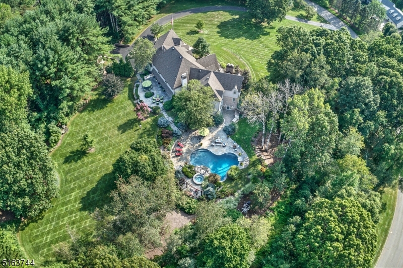 MUST SEE: Everything about this custom home speaks quality, from the masonry stucco exterior to the architectural details throughout.The 2-story foyer allows direct access to 3 areas of the home: Quiet area is the formal living room with French doors leading to paneled office with wet bar, refrigerator & built-ins; magnificent dining room has 13-foot ceiling, custom window wall framing breathtaking distant views & generous butler's pantry; casual rooms include the richly appointed kitchen with 2 islands, 3 sinks, 2 dishwashers, 6 burner Wolf range, Sub Zero refrigerator, & cozy fireplace nook. Coffered ceiling accents the family room w/stone surround fireplace. Both kitchen & family room have double sets of sliding doors adding a light, bright feeling & giving access to an outdoor kitchen, expansive terraces, pool, spa & fenced back yard. The sumptuous main bedroom offers 12 foot ceiling, fireplace & full wall custom window. This suite includes a room-sized fully fitted closet & elegant bath. The 2nd floor has 3 additional en suite bedrooms & laundry room. A separate in-law suite with living room & bath facilitates multi-generational living. The walk-out lower level convenient to pool offers kitchenette, bath, game room accented by fireplace w/stone surround. A hobby & workout room complete the lower level. Take time to enjoy the perennial gardens, distant views & the spectacular sunsets this 5 acre setting provides. SQFT from Tax Records.