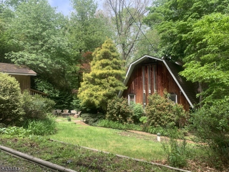 This unique A-frame home located at 4 Pine Tree Ln in Chester, NJ has a warm, enchanting atmosphere. It is nestled in the woods in a quiet and private neighborhood yet convenient to Chester, Roxbury, Mendham, and Randolph town centers. With highly rated schools,  Dickerson/Bragg Elementary, Black River Middle, and West Morris Mendham High Schools.The layout proves that great things come in small packages. With 2 bedrooms, 2.5 bathrooms, and a small bonus room, the footage space goes a long way. The main floor is open concept with full bathroom, living, dining, kitchen, and office space, complete with a wood burning stove. Lower level includes master bedroom, full bath with jacuzzi tub, laundry/utility, and a small bonus room. This floor walks out onto a stone patio overlooking acres of tranquil wooded land. Loft level has 2nd bedroom and 1/2 bathroom, ample closet and storage space, plus a cozy alcove for guest sleeping. Additionally, the loft features a balcony that steps out into the tree tops. Other special features of this property include: detached one car garage, and 3 out buildings. The largest out building has been fashioned into a serene studio space. The acreage backs up to a public path that spans from Chester to Roxbury's Horseshoe Lake.Also recently added: chicken coop, fenced area in back yard, and large woodshed.  If you love the outdoors this place is for you!