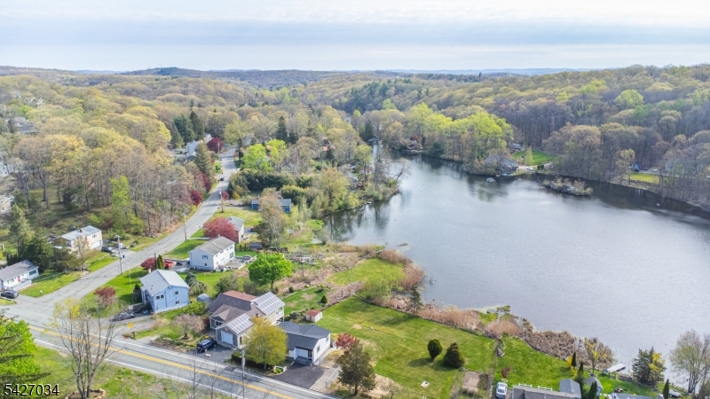 Welcome to this fully renovated lakefront gem in the desirable Mount Glen Lakes section of West Milford. Set on an oversized, level 0.40-acre lot with direct lake frontage and year-round water views, this 3-bedroom, 2-bath ranch offers the perfect blend of modern design and effortless one-level living. Completely redesigned in 2025, every detail has been thoughtfully updated for today's lifestyle. Step inside to a bright, open living/dining area with beautiful wood floors and abundant natural light. Sliders off the living room lead to a deck overlooking the lake   the perfect place to relax or entertain while enjoying peaceful waterfront scenery in every season. The stunning new kitchen features sleek cabinetry, stylish countertops, and stainless steel appliances, including a gas range.  One bedroom features its own private full bath, while two additional bedrooms share a second beautifully renovated bath. A convenient main-floor laundry closet is located in the hallway for easy access.  The lower level offers excellent storage space and houses the utilities. With central air, natural gas heat, a blacktop driveway, lake privileges, and turnkey condition throughout, this is true one-level lake living at its finest. Grass in the photos has been digitally altered to be greener.