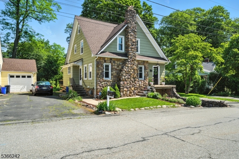 Charming Fieldstone Tudor on the Rockaway River just a short walk to Downtown Denville! This meticulously maintained waterfront home blends classic craftsmanship with modern upgrades. Step inside to find oak hardwood floors, crown molding, and a beautiful stone fireplace with gas insert in the living room. The formal dining room features a built-in bar and wine fridge, perfect for entertaining. The updated kitchen offers stainless steel appliances, butcher block island, designer backsplash, and generous counter space. A sunlit family room with a wall of windows overlooks the serene, park-like yard and river. Upstairs are four uniquely charming bedrooms, a full bath, and a finished attic offering bonus space. Full basement provides excellent storage. Enjoy outdoor living on the deck with built-in natural gas grill. Modern updates include central air on all three floors, new appliances, updated 200A electrical, and L2 EV-ready NEMA 14-50 outlet. Located outside the flood zone, yet right on the Rockaway River. Walk to shops, dining, and direct transit to NYC via train or bus. A rare opportunity to own a home full of character, comfort, and convenience in one of Morris County's most desirable communities! (NOT IN A FLOOD ZONE - Seller does not pay insurance)