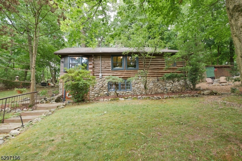Wake up and feel like you're on vacation. This custom Kinnelon cabin offers a woodsy retreat one house off the lake. It features an oversized living room with vaulted ceilings and a charming stone fireplace that feels straight from a ski lodge. Three skylights allow for extra natural light through the home. The private backyard with multiple entertaining areas faces the mountain, front yard faces the lake. Top-rated schools and 3 miles to the modern conveniences of Rt 23. Nature right out your window or get outside to enjoy the lake life and beauty that this community offers. Swimming, hiking, tennis, pickleball, fishing, community boat docks, community events, mountain biking 500' from your door.