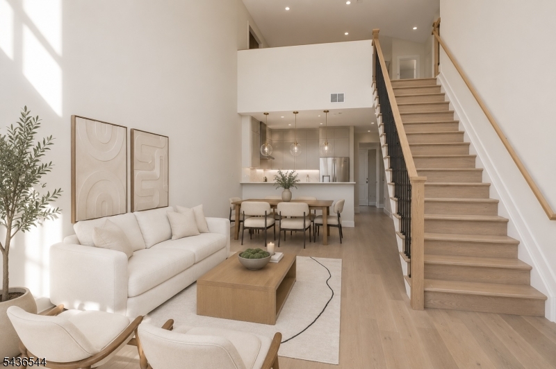 Step into sophisticated modern living in this beautifully designed duplex, where luxury finishes and thoughtful details come together seamlessly. Featuring an airy open-concept layout, this exceptional residence showcases stunning 7  white oak hardwood floors throughout and a sleek designer kitchen complete with top-of-the-line Viking appliances, Calacatta quartz countertops, and a matching full-height backsplash.The expansive living and dining areas are highlighted by dramatic 21-foot ceilings and an 8-foot sliding glass door that opens to a private balcony, allowing natural light to pour throughout the home.The first floor offers a full guest bathroom with a soaking tub, one spacious bedroom, and a second bedroom with a connected en-suite bathroom featuring double sinks and a glass-enclosed stand-up shower. Additional conveniences include an in-unit stackable washer and dryer, coat closet, Nest thermostat, intercom system, and two-zone heating and cooling.Upstairs, the second level features the primary bedroom, an additional full bathroom, and an oversized media room ideal for entertaining, relaxing, or creating the perfect home office setup. Assigned garage parking is available for an additional cost. Ideally located near downtown South Orange, restaurants, shopping, and NJ Transit Midtown Direct service, this home offers the perfect combination of style, comfort, and convenience. Schedule your private showing today!