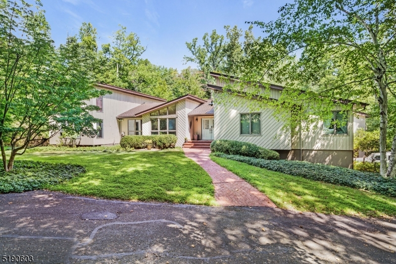 Nature abounds in this gorgeous contemporary ranch which sits on a private flag lot. This custom home offers an abundance of privacy...your own peaceful oasis...yet it is located on a cul-de-sac street in a conveniently located neighborhood which is close to shopping, schools and restaurants. Built for entertaining as well as relaxation, upon entering the home you notice the expansive open floor plan, including a modern kitchen with custom cabinetry, vaulted ceilings and a skylight. The primary BR includes a WIC, a spacious adjoining leisure room, and a spectacular bath area with a jetted tub, 2 separate sink areas, and a huge shower w/two distinctive separate shower heads. A private wing with a separate entrance boasts a nicely sized BR, a full bath and a den with a loft as well as a soothing spa room..complete with an indoor hot tub, sauna, dressing room and large windows allowing views of the serene outdoors. The finished basement features custom wood wainscotting throughout, a recreaction room, a media room, and an exercise room. The expansive private wooded backyard complete with a babbling stream includes a large concrete inground pool with built in spa, a separate gazebo for dining to the side of the pool area, a paver patio with a custom fire pit as well as an expansive upper deck area overlooking the backyard. This unique property must be seen to appreciate the unique floor plan and custom features. Best of all... this property can be yours!